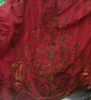 Primo piano di un panno rosso con ricami.