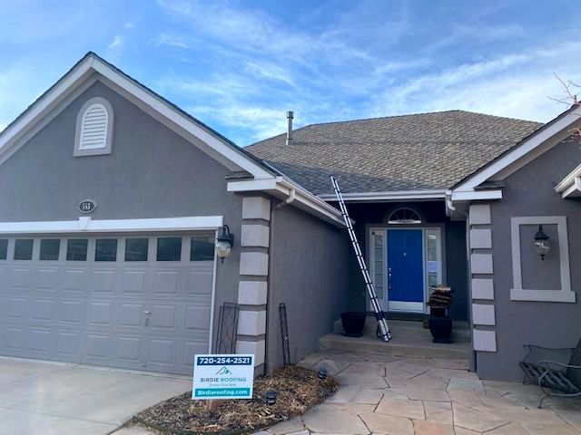 A house with a blue door and a sign in front of it