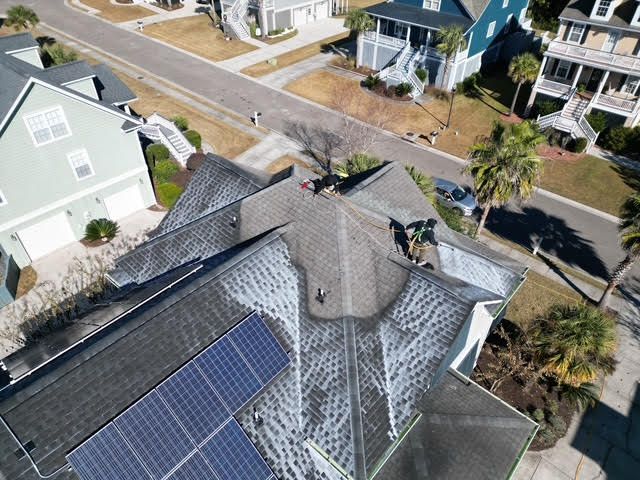 An aerial view of a large house with a car parked in front of it.