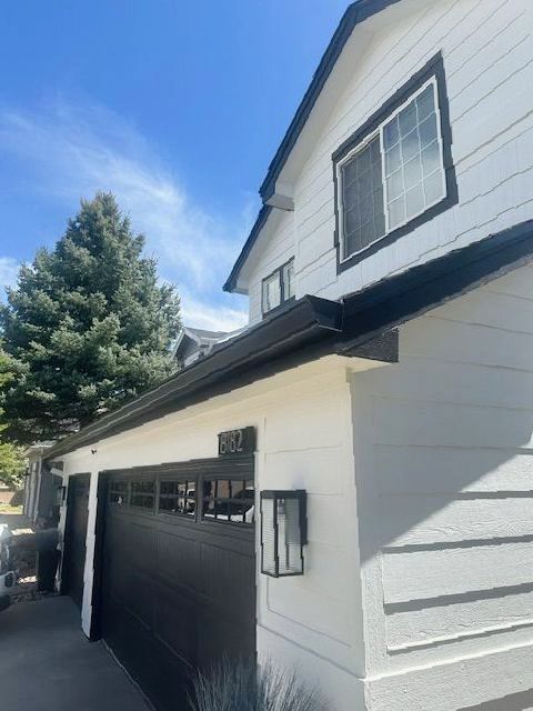 A white house with a black garage door