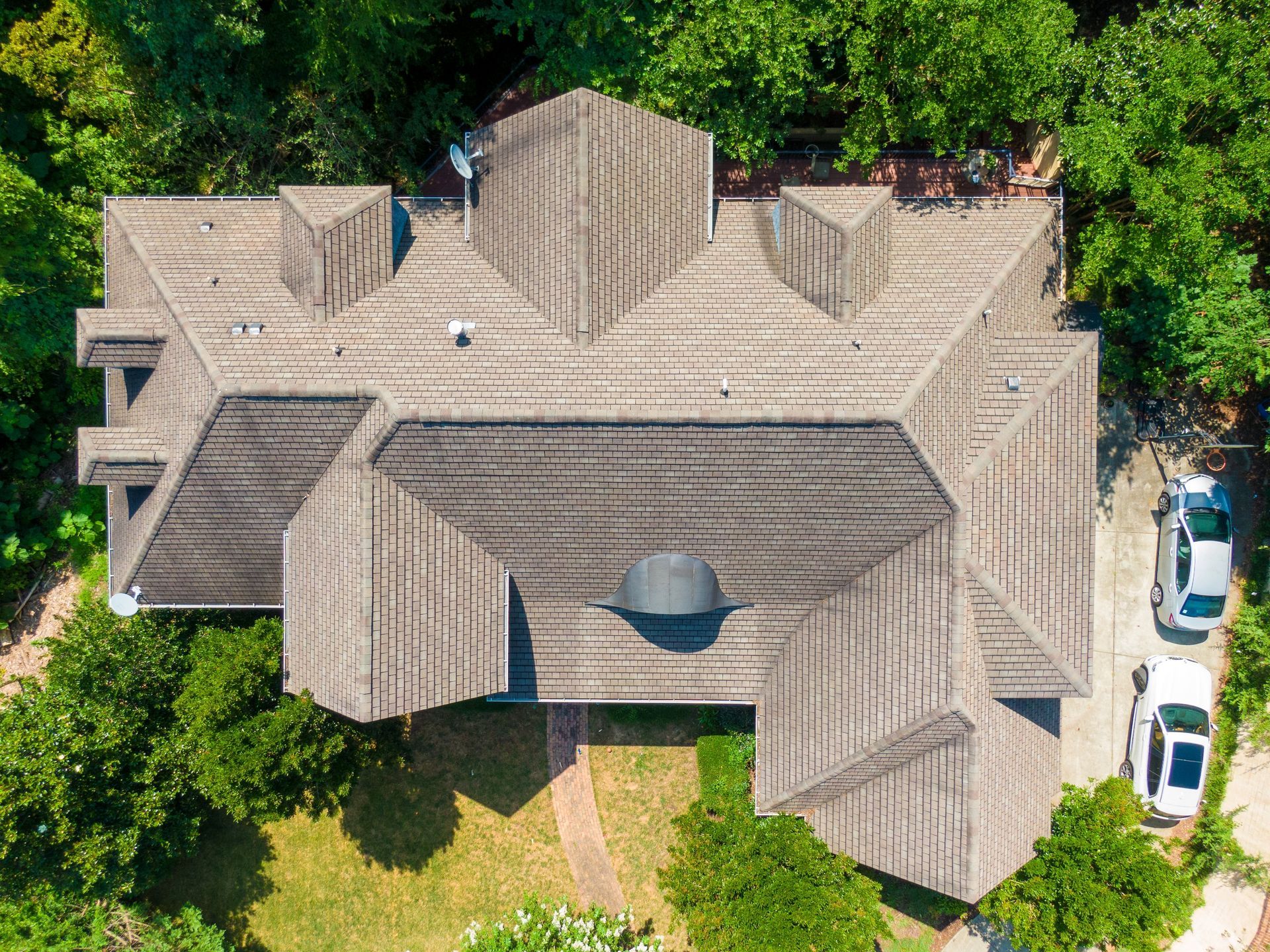 An aerial view of a large house with a car parked in front of it.