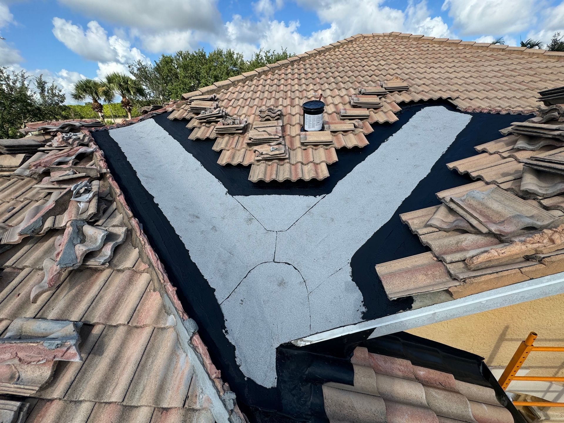 Roof with broken tiles, underlayment exposed in a 
