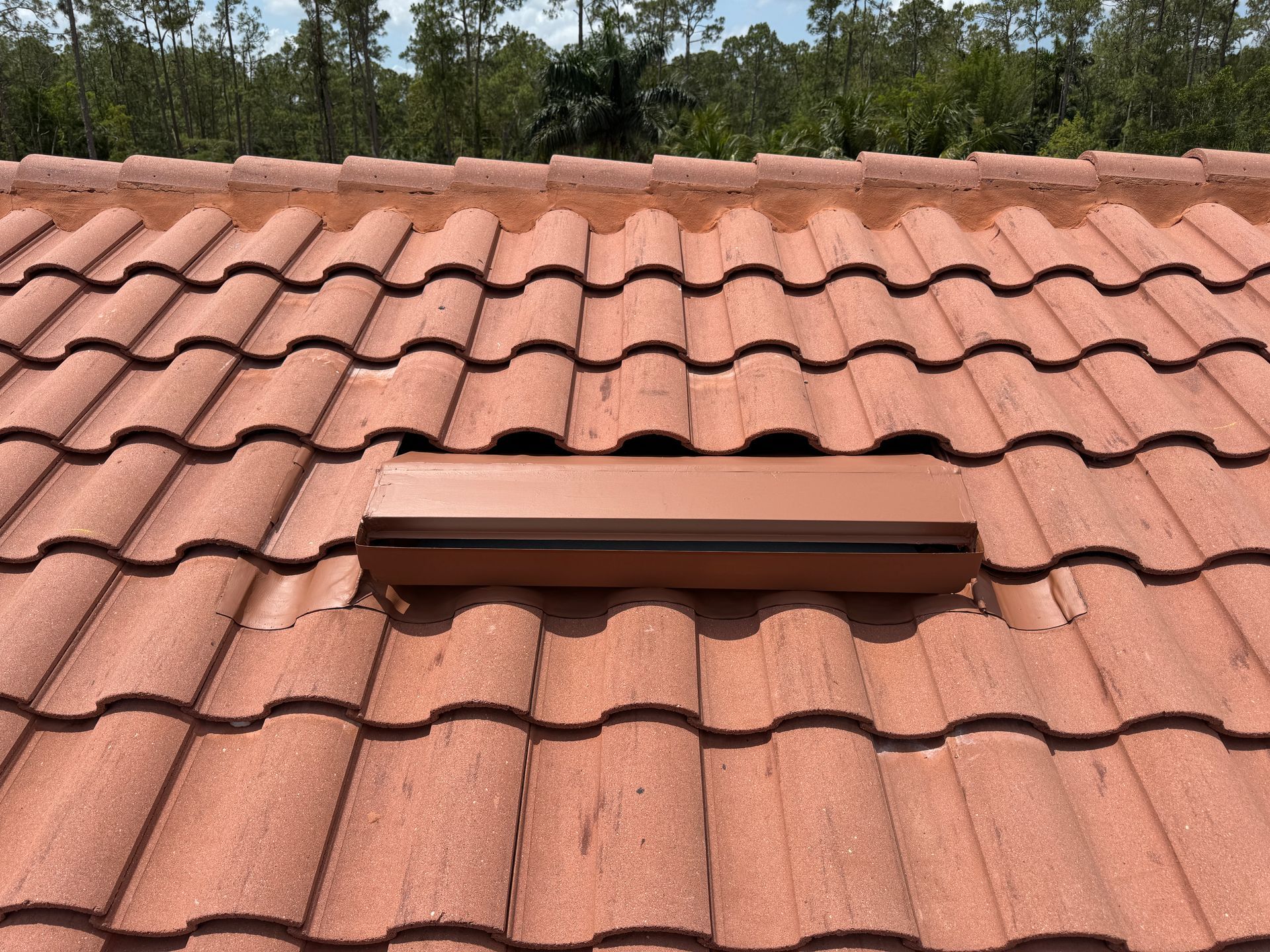 Brown tile roof with a rectangular vent.