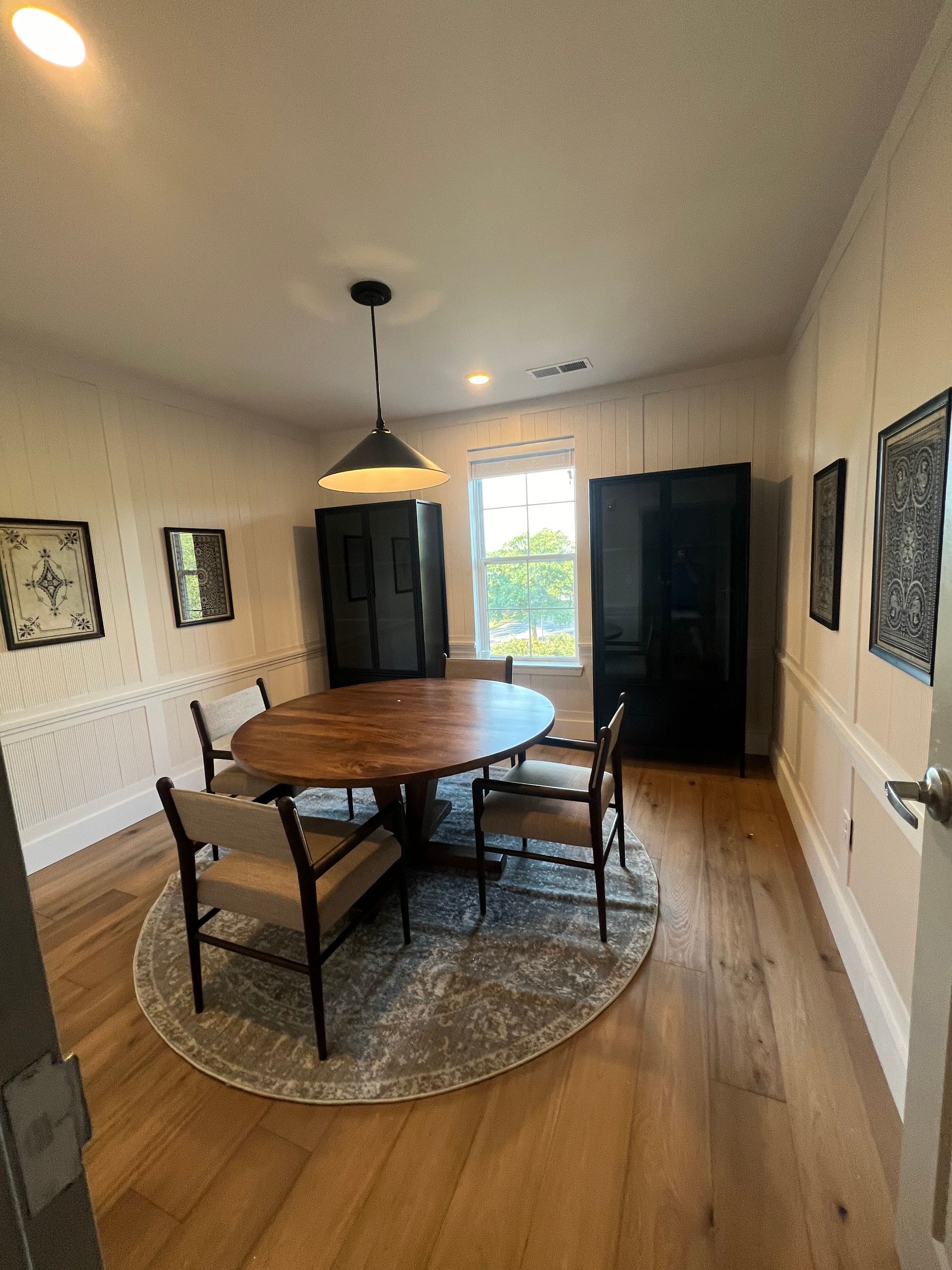 A dining room with a round table and chairs