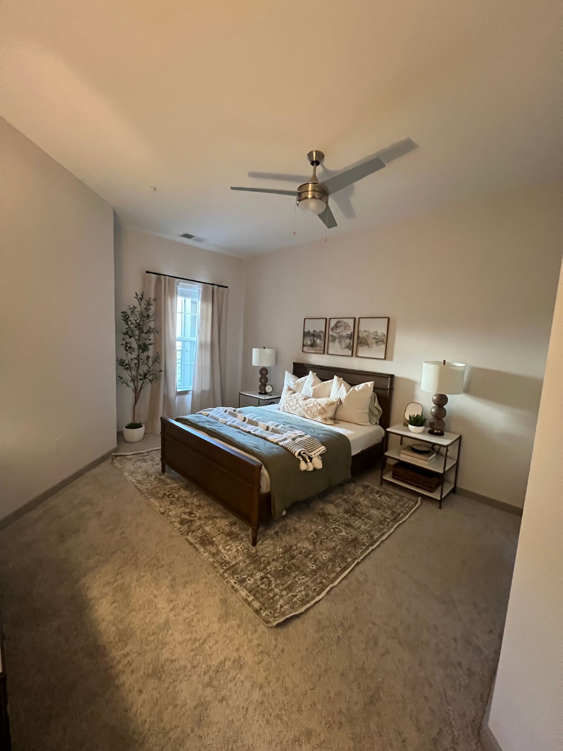 A bedroom with a large bed and a ceiling fan.