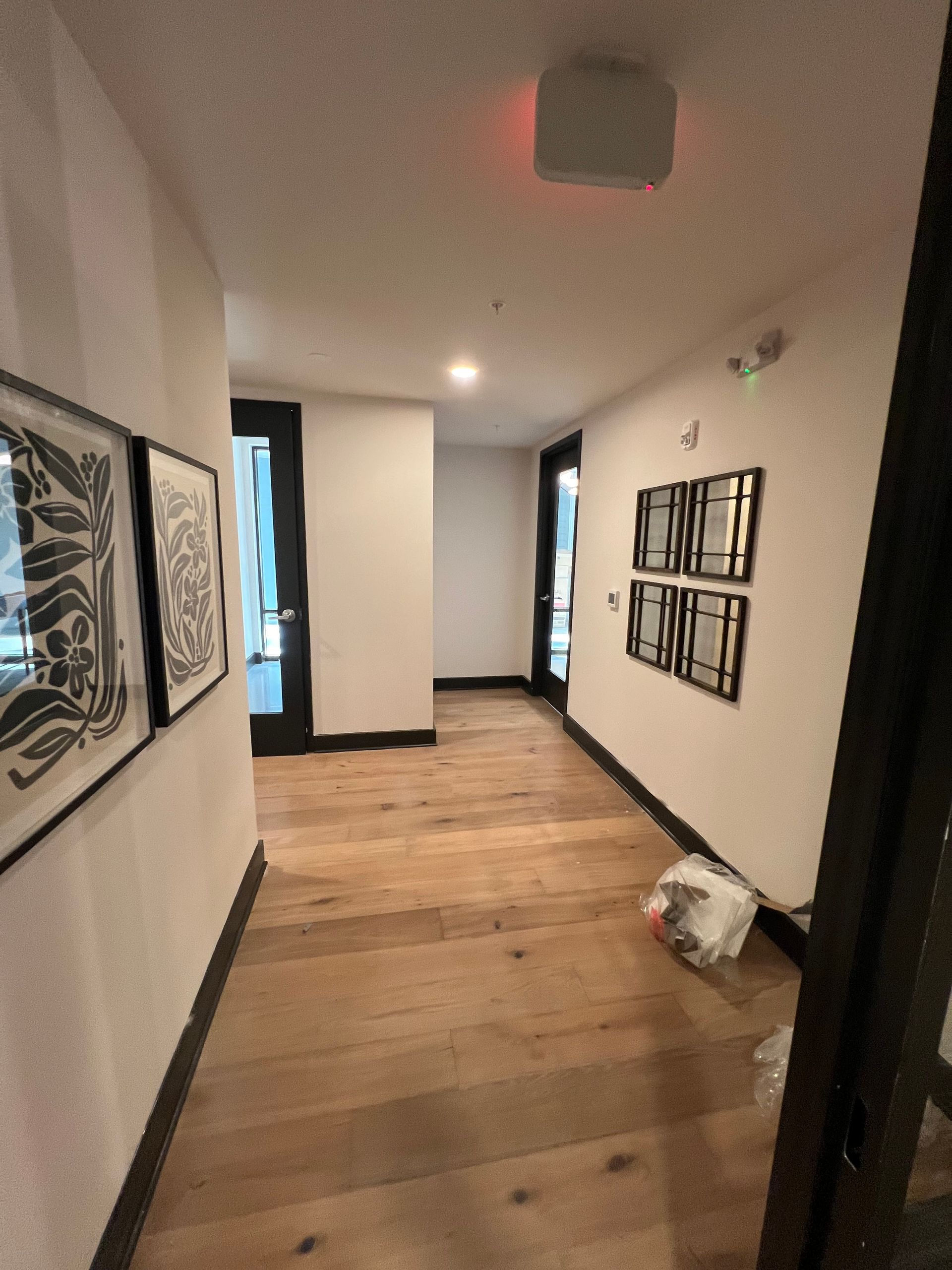 A hallway with wooden floors and white walls