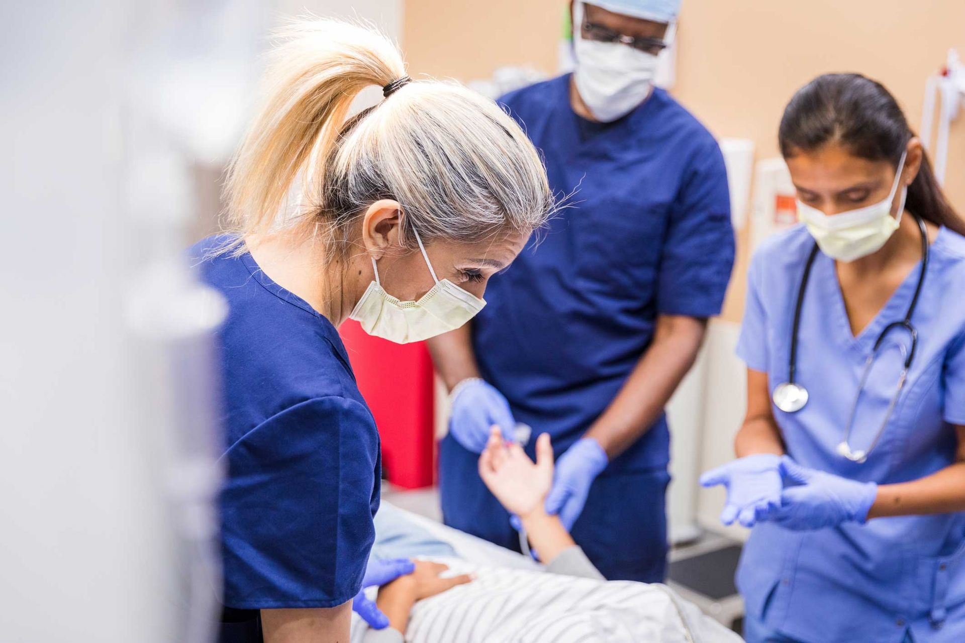 A group of doctors and nurses are working on a patient in an operating room.
