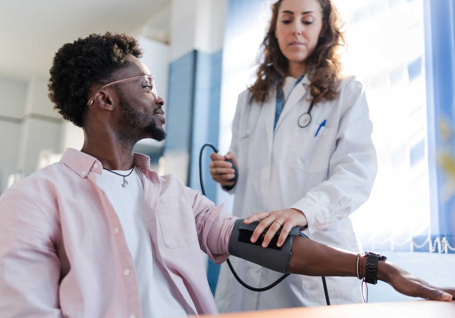 A doctor is talking to a patient while holding a tablet.
