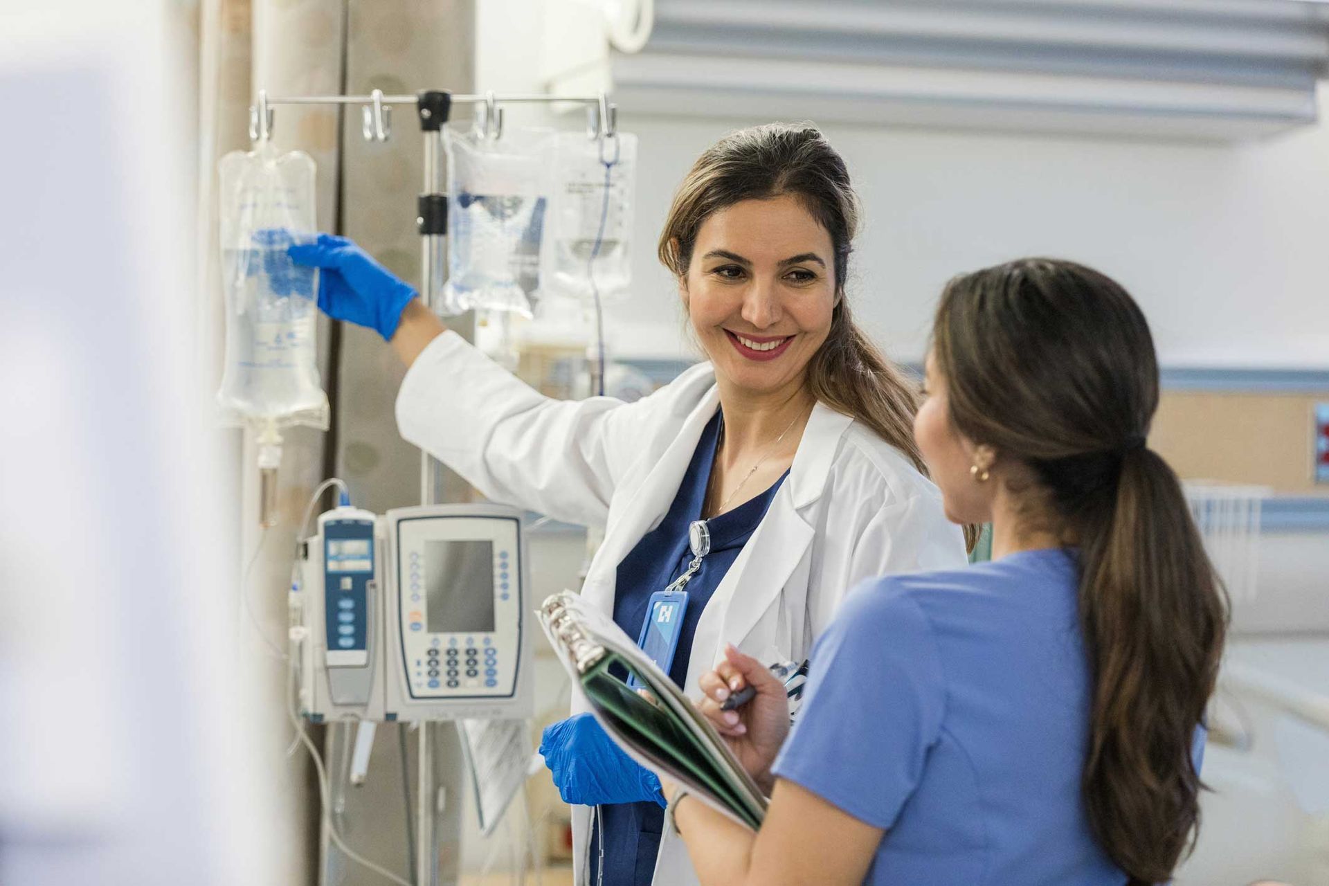 A doctor and a nurse are standing next to each other in a hospital room.
