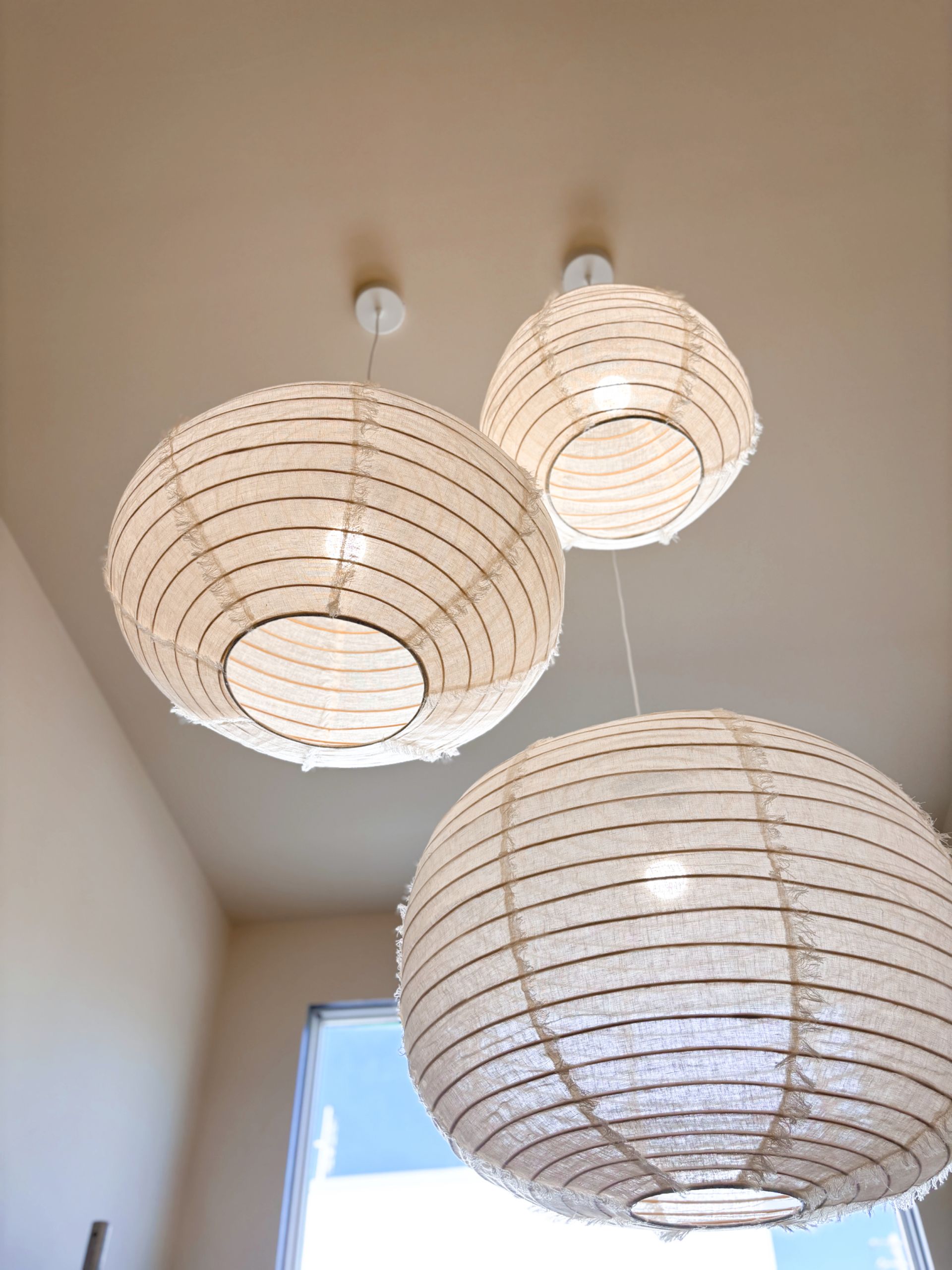 Three white lanterns are hanging from the ceiling in a room