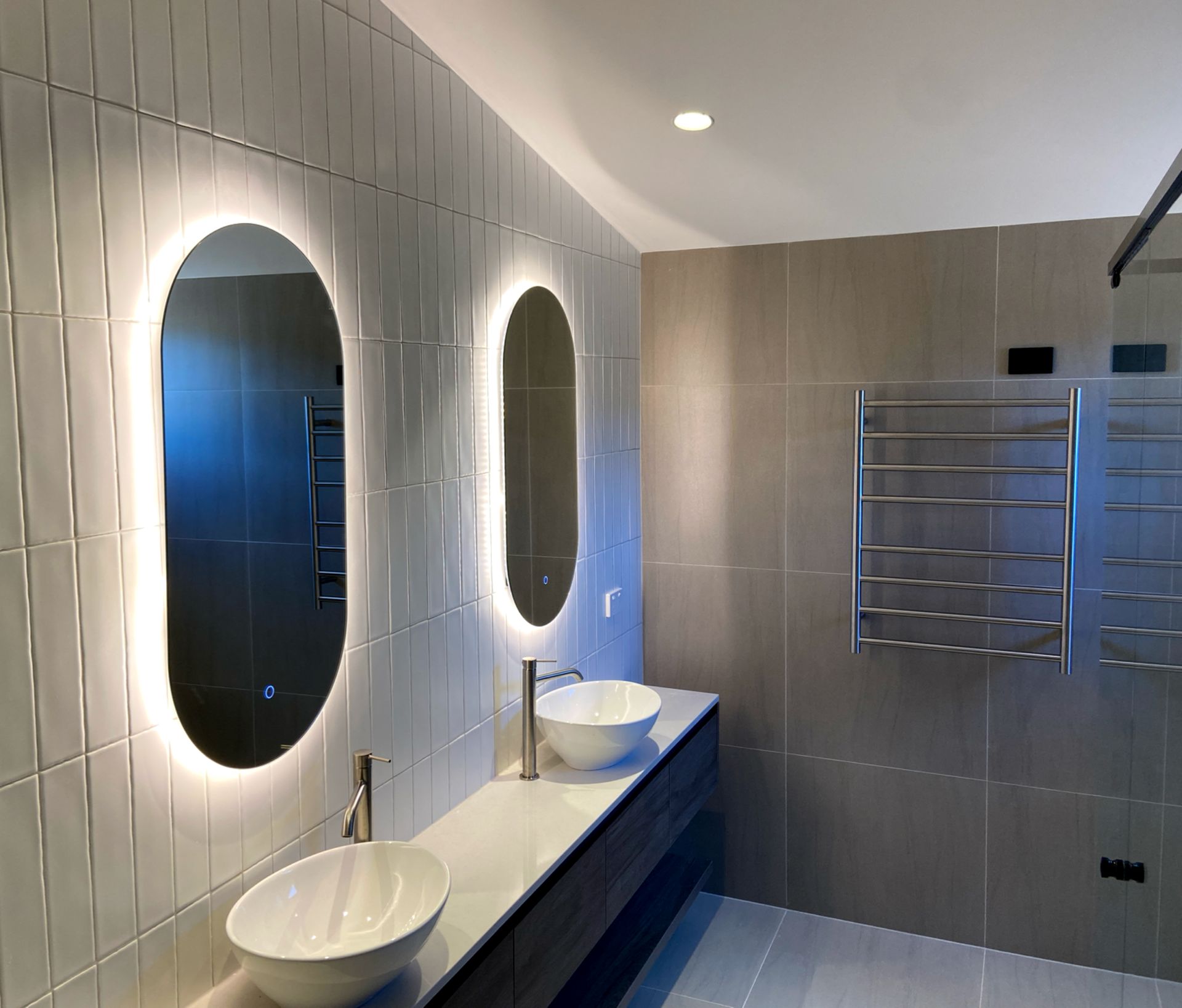A bathroom with two sinks and two mirrors with LED lights. Home Electrical.