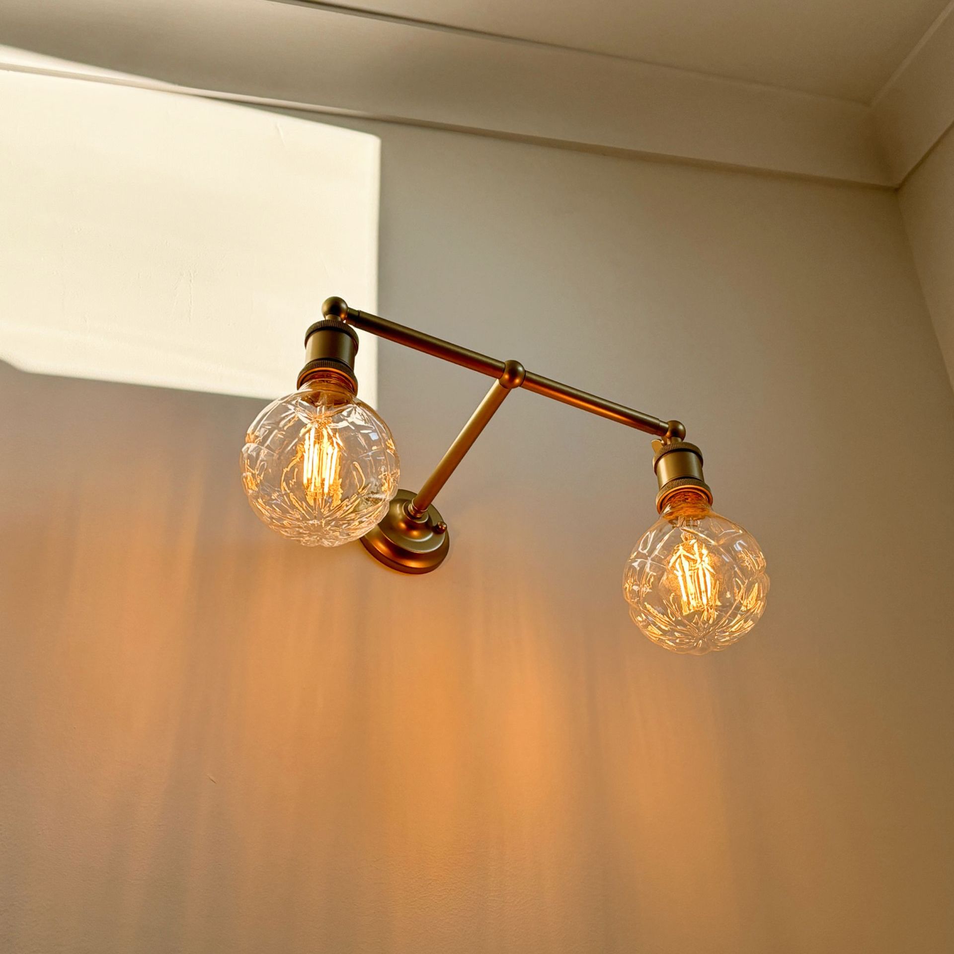 Fat Shack featuring wall light with two light bulbs are hanging from a brass pole on a wall