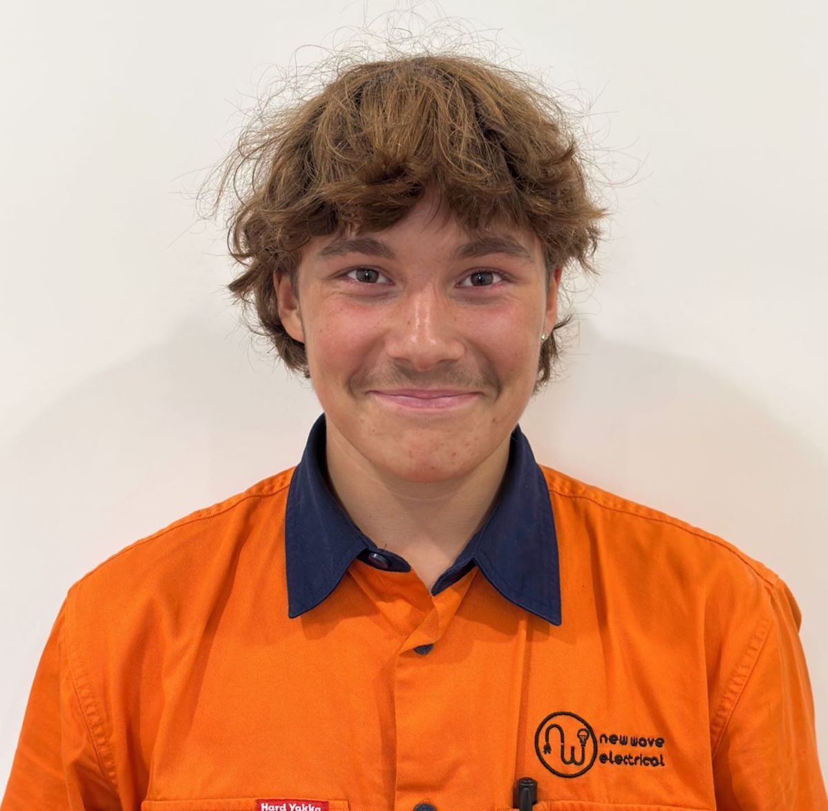 An Electrician smiling man wearing an orange shirt