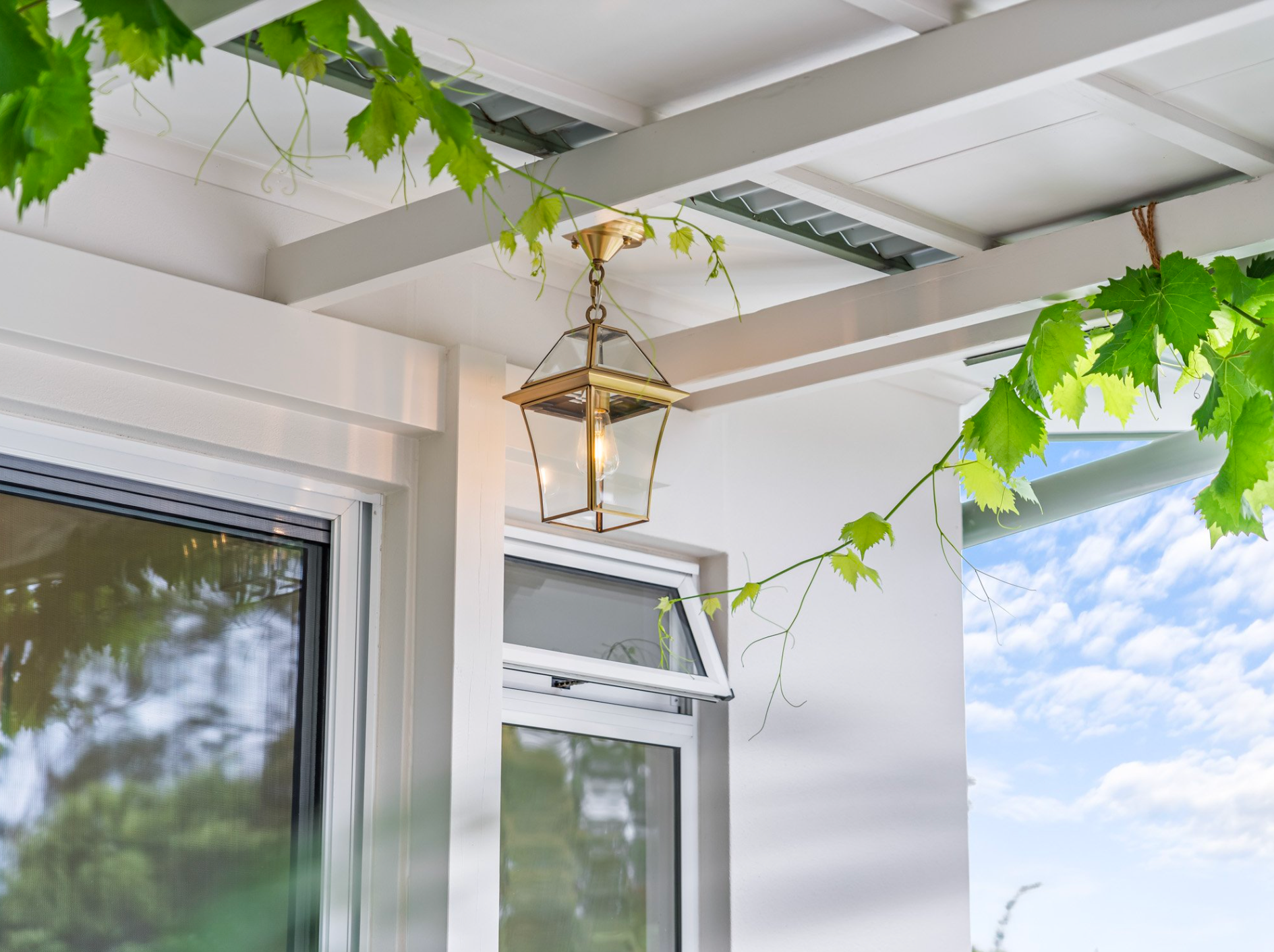A Fat Shack lantern is hanging from the ceiling of a porch.