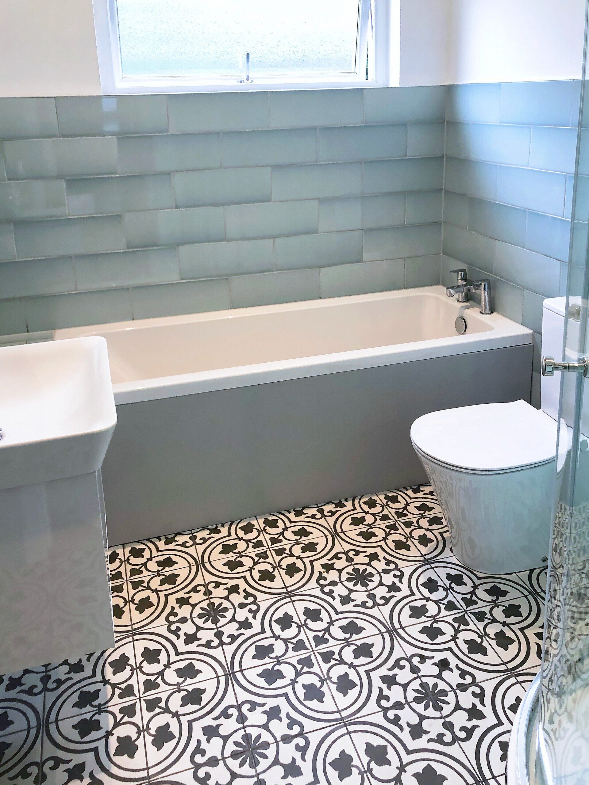 A bathroom with a bathtub , toilet , sink and shower.