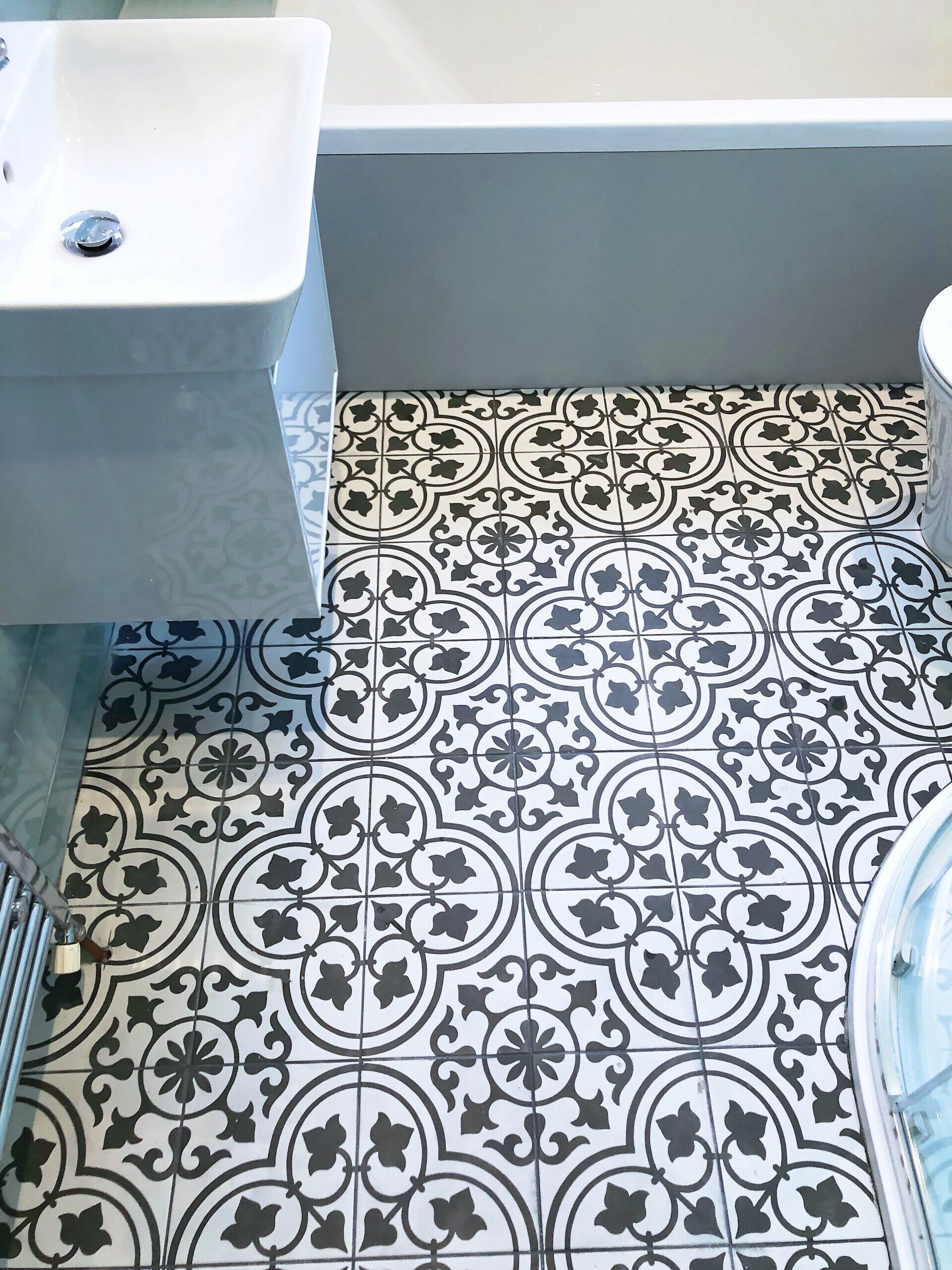 A bathroom with a bathtub , sink , toilet and tiled floor.