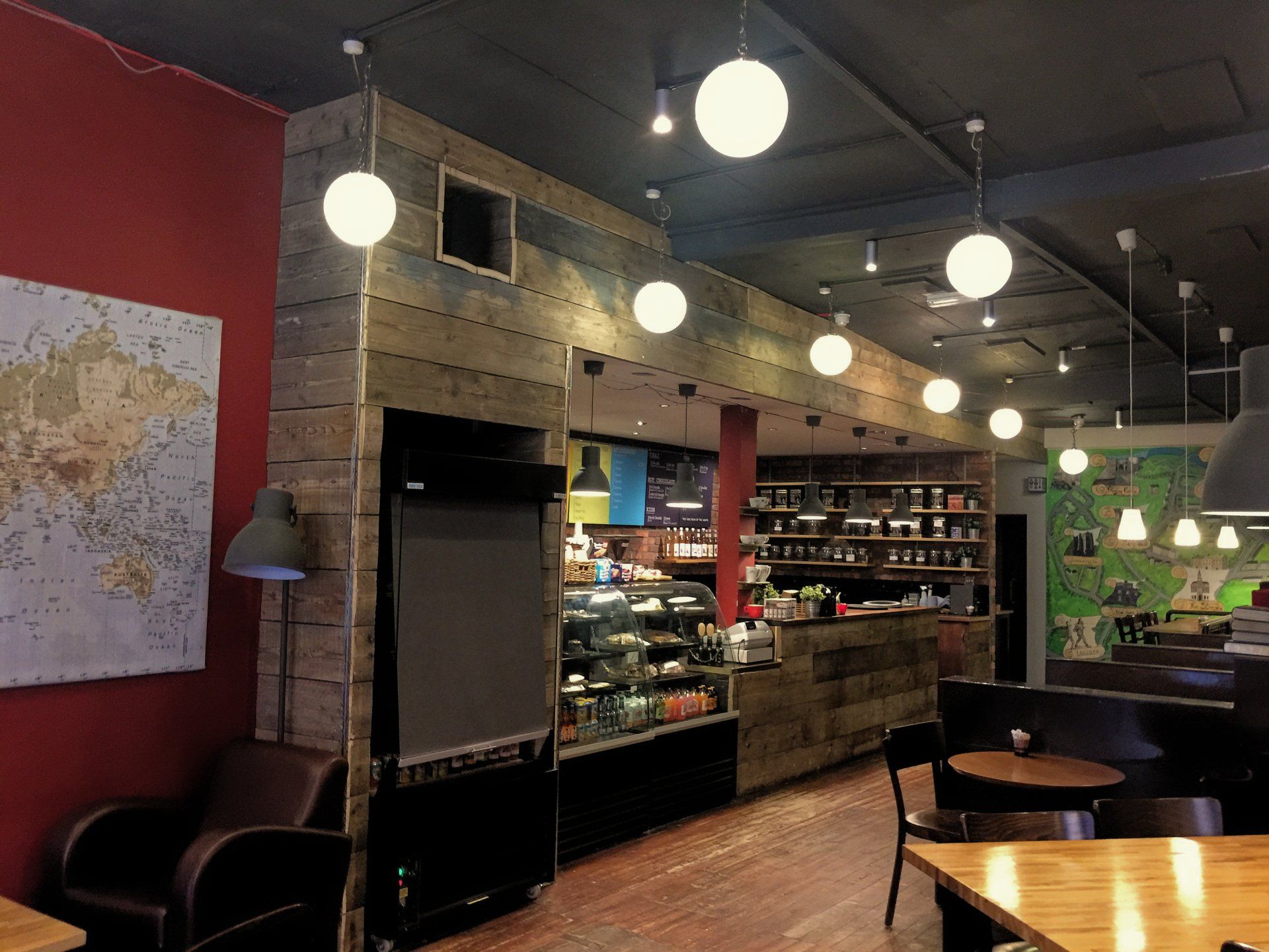 A restaurant with tables and chairs and a map on the wall.