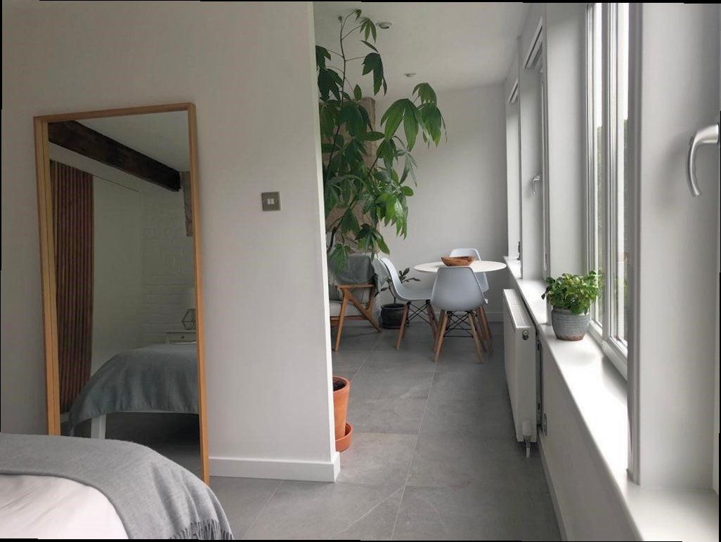 A bedroom with a bed and a large mirror