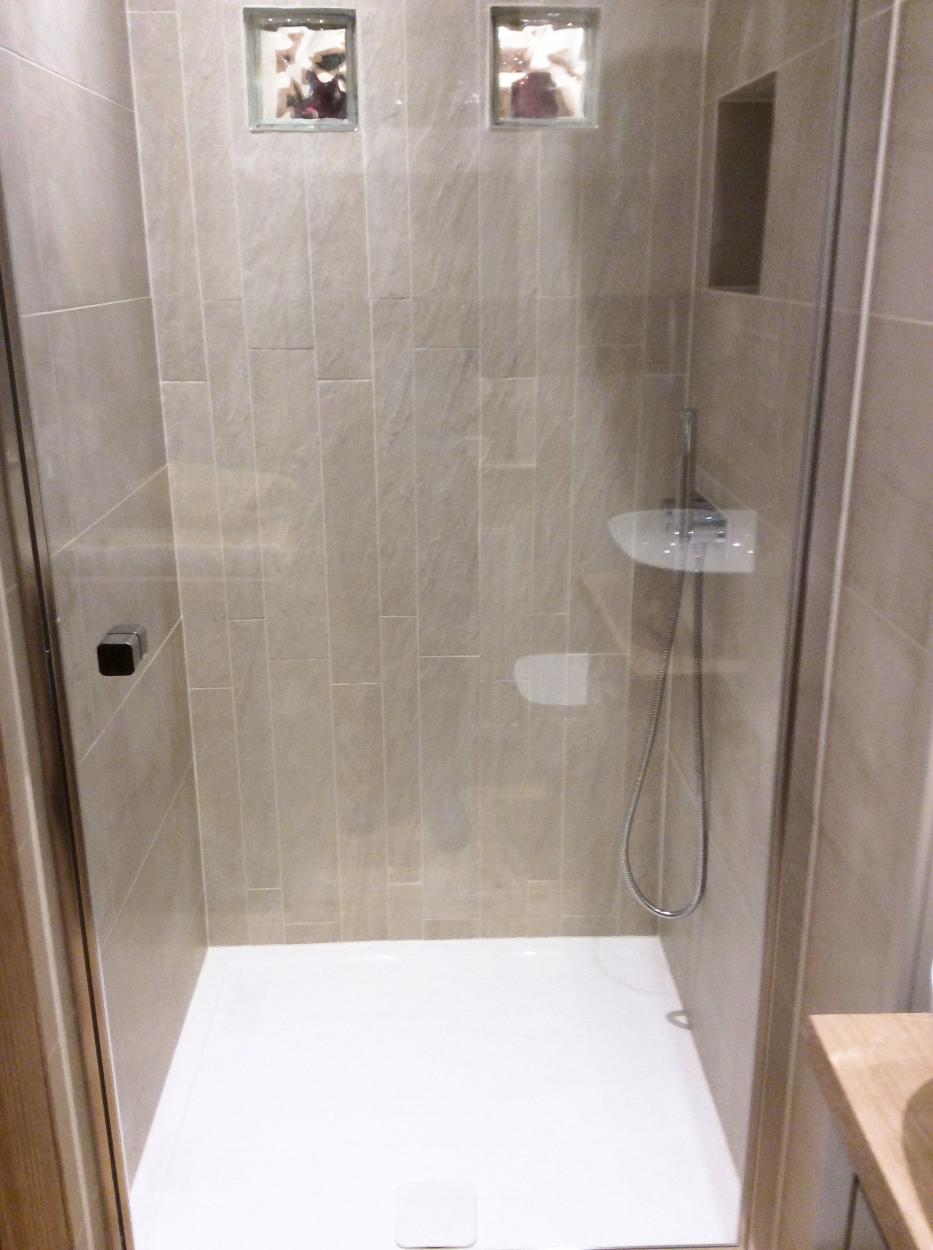 A bathroom with a walk in shower and a sink.