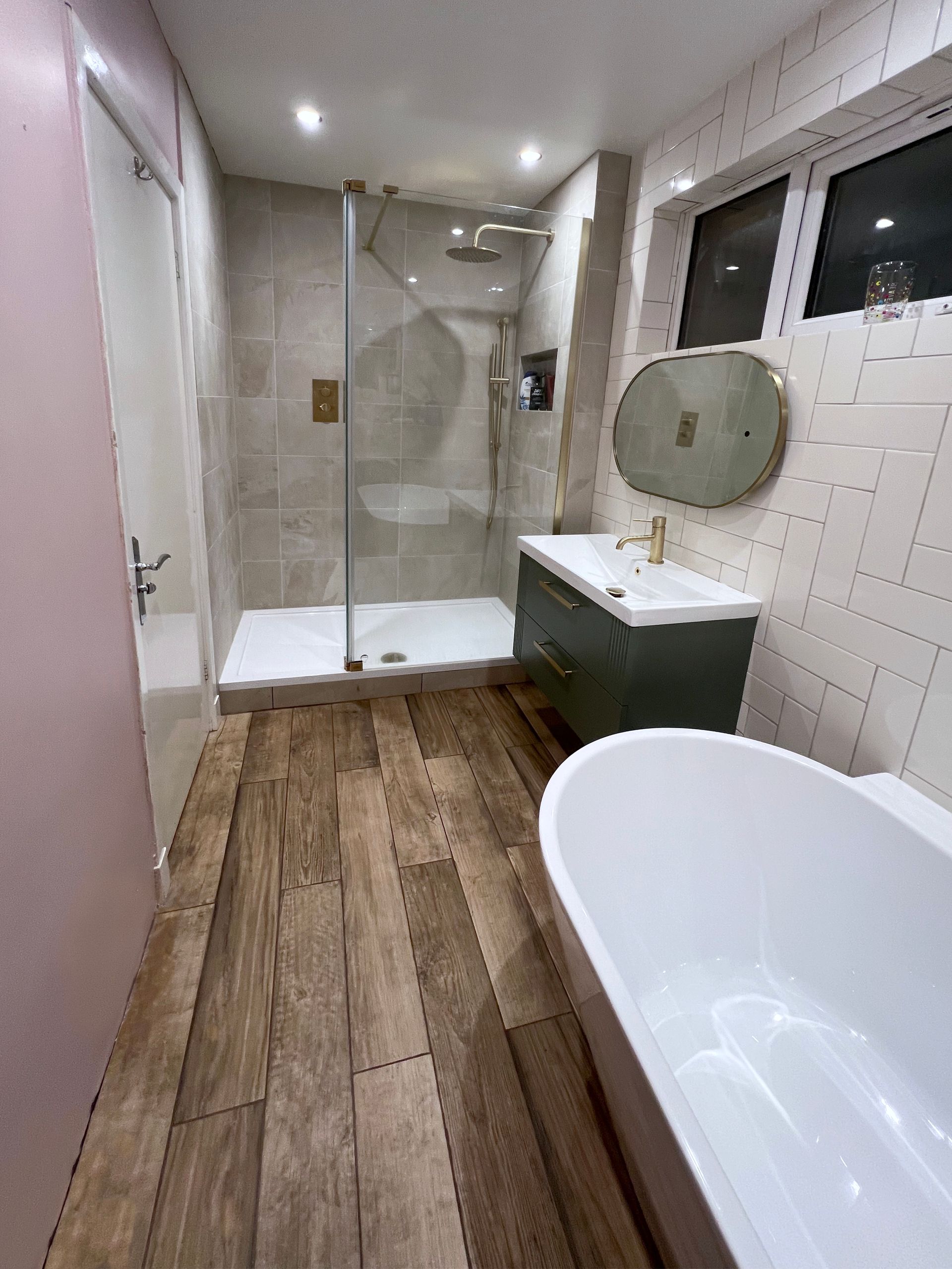 A bathroom with a bathtub , sink , shower and mirror.