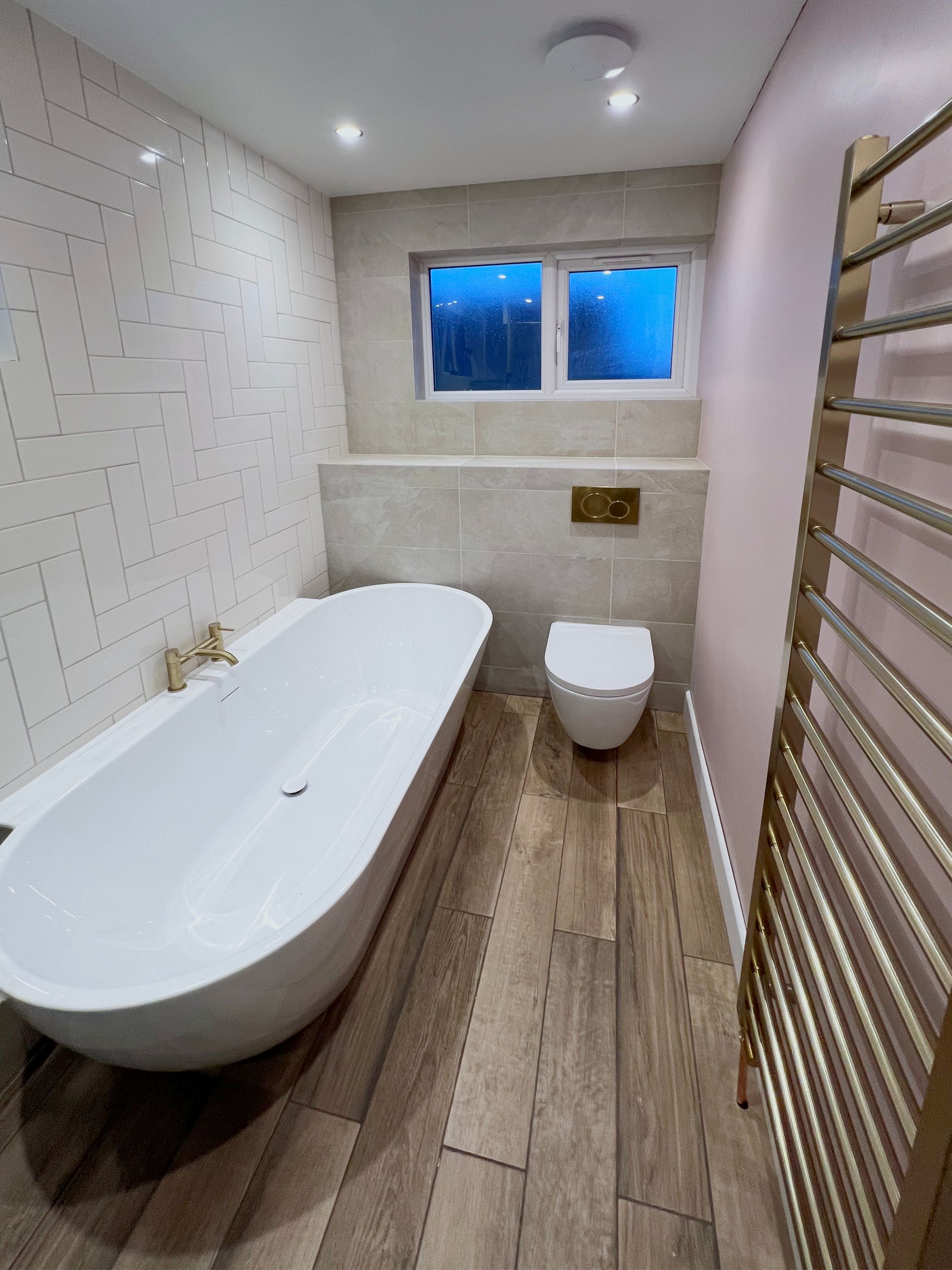 A bathroom with a bathtub , toilet , and towel rack.