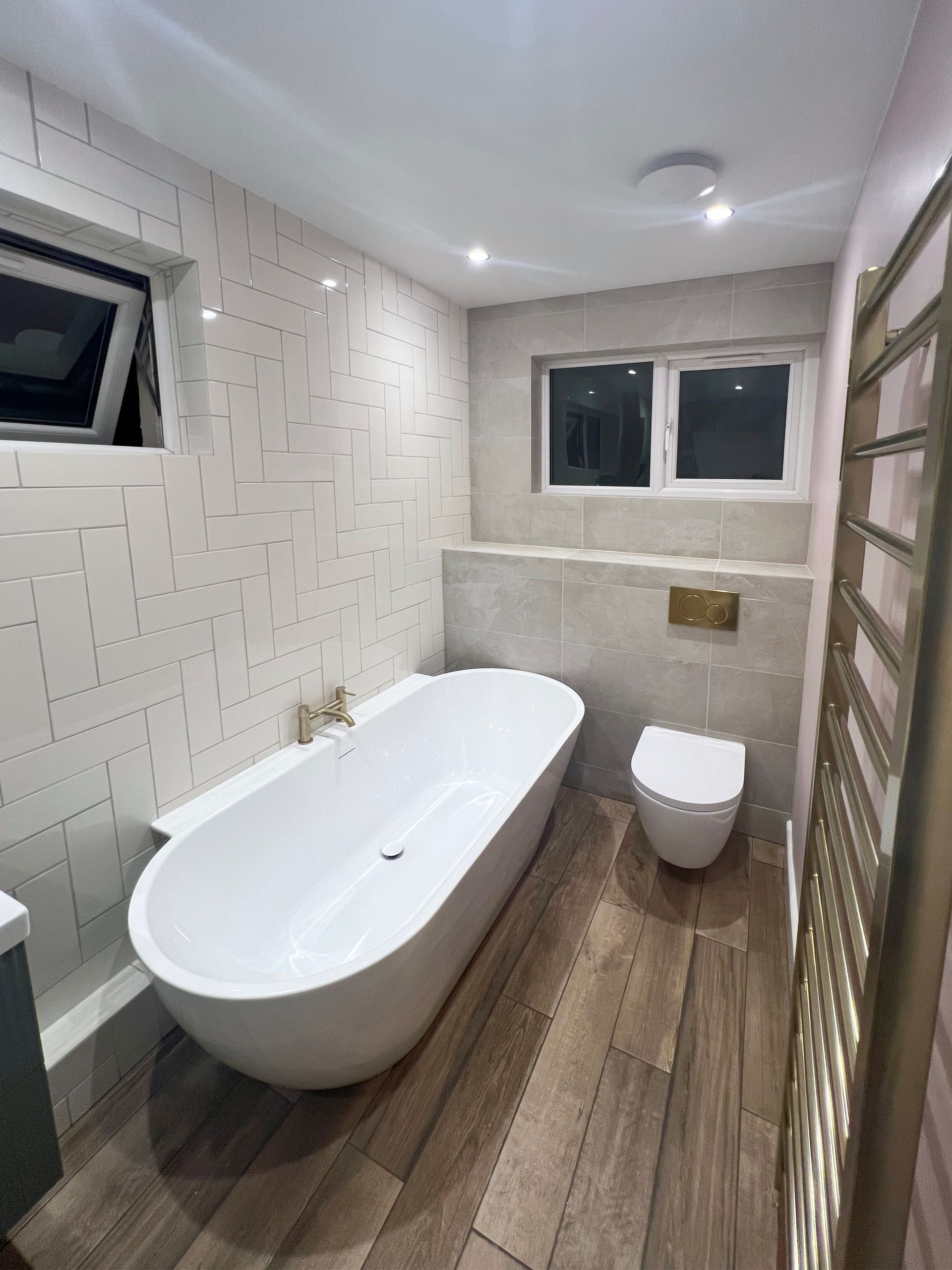A bathroom with a bathtub , toilet and window.