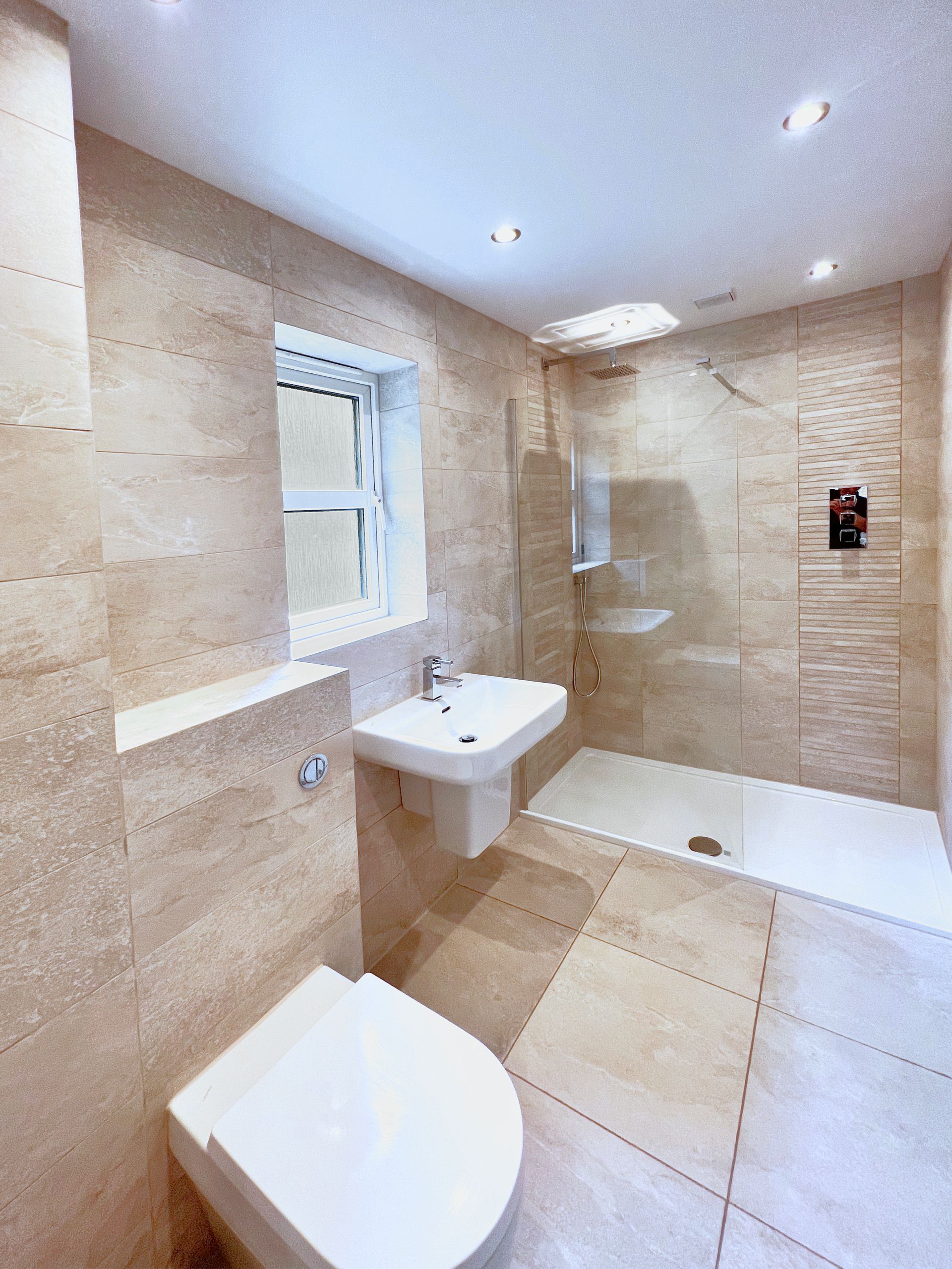 A bathroom with a toilet , sink and walk in shower