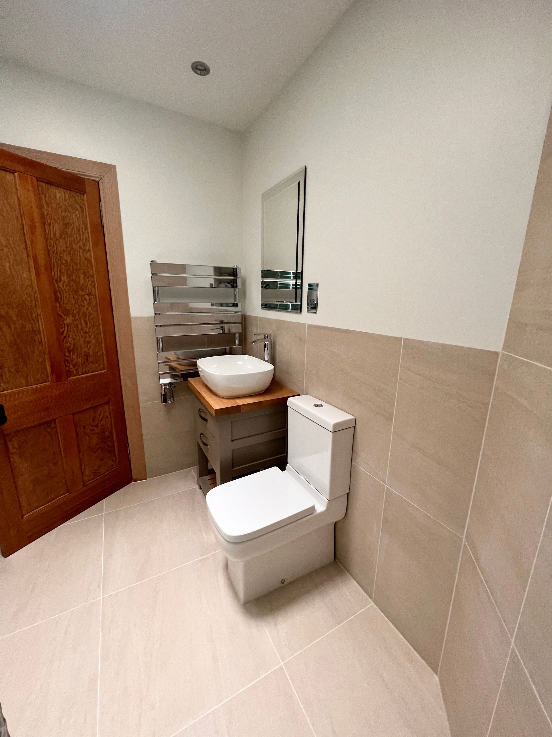 A bathroom with a toilet , sink and mirror.