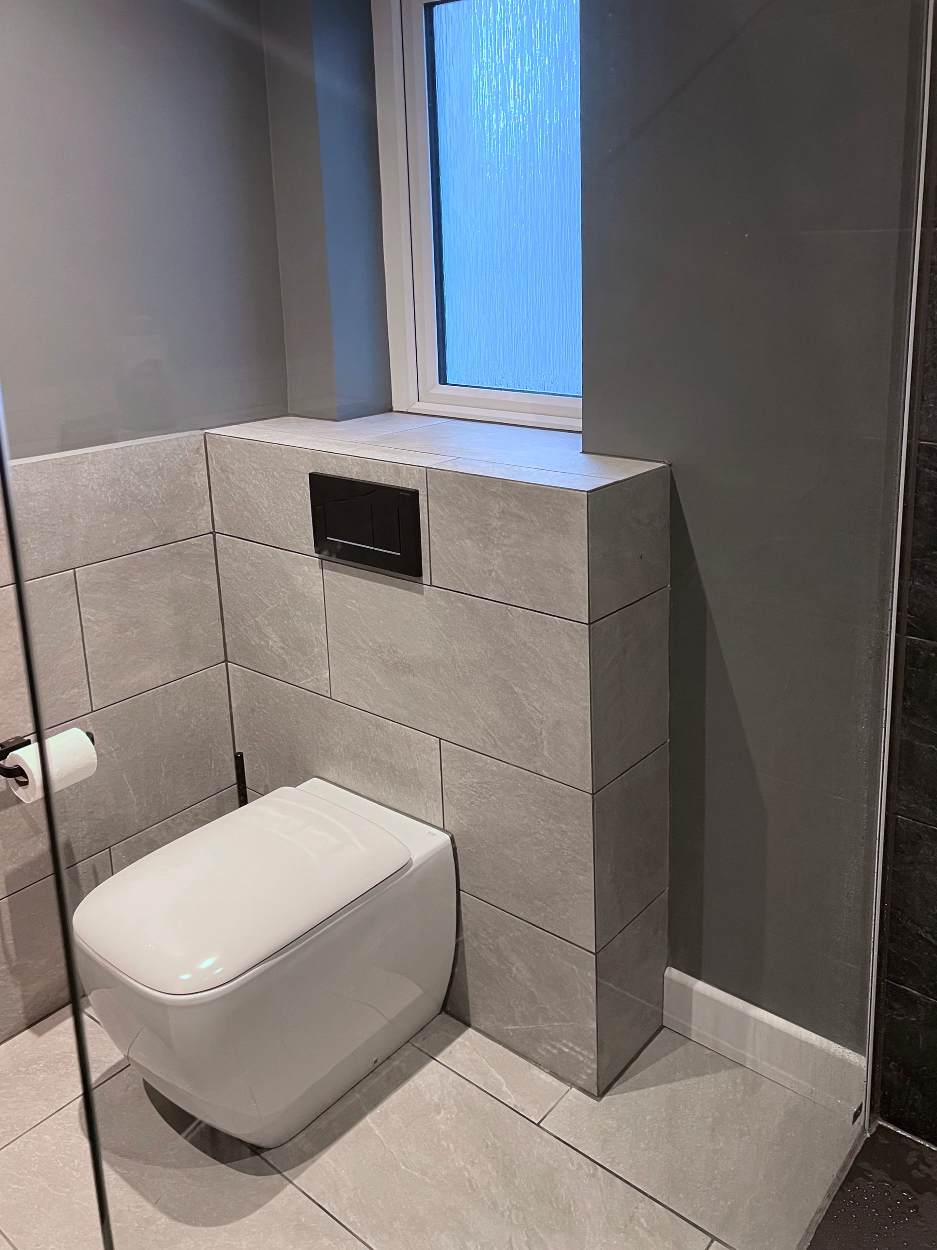 A bathroom with a toilet and a window.