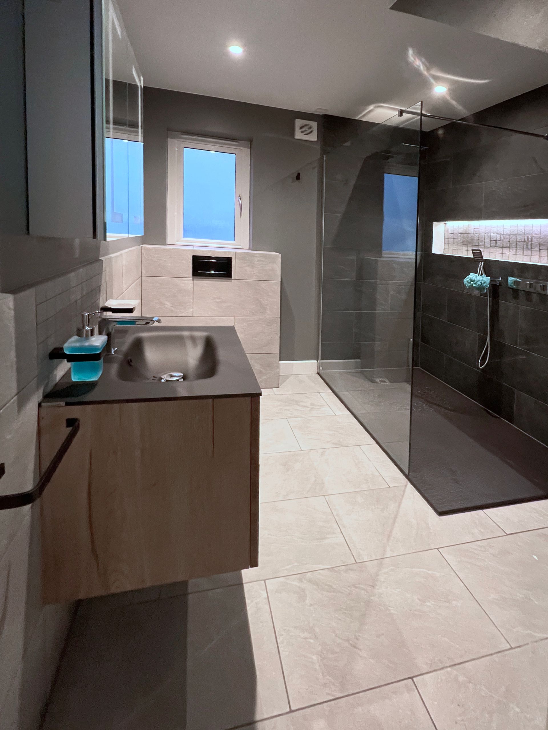 A bathroom with a modern sink and a walk in shower.