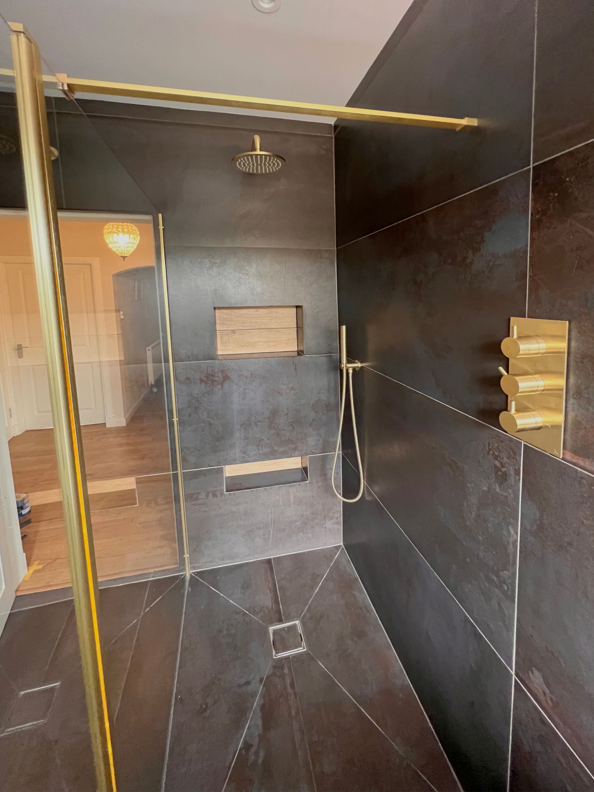 A bathroom with a walk in shower and a shower head