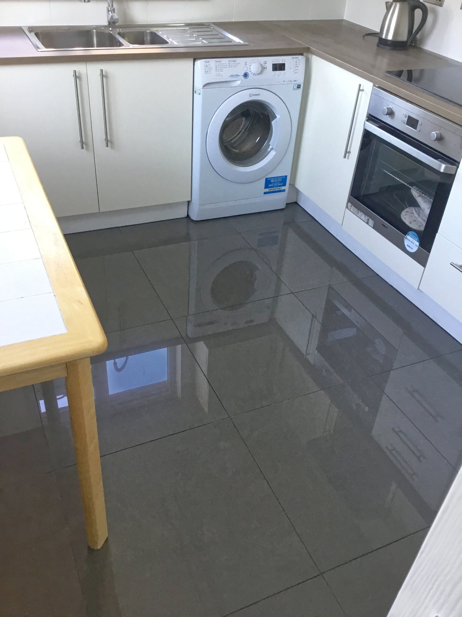 A kitchen with a washer and dryer and a table.