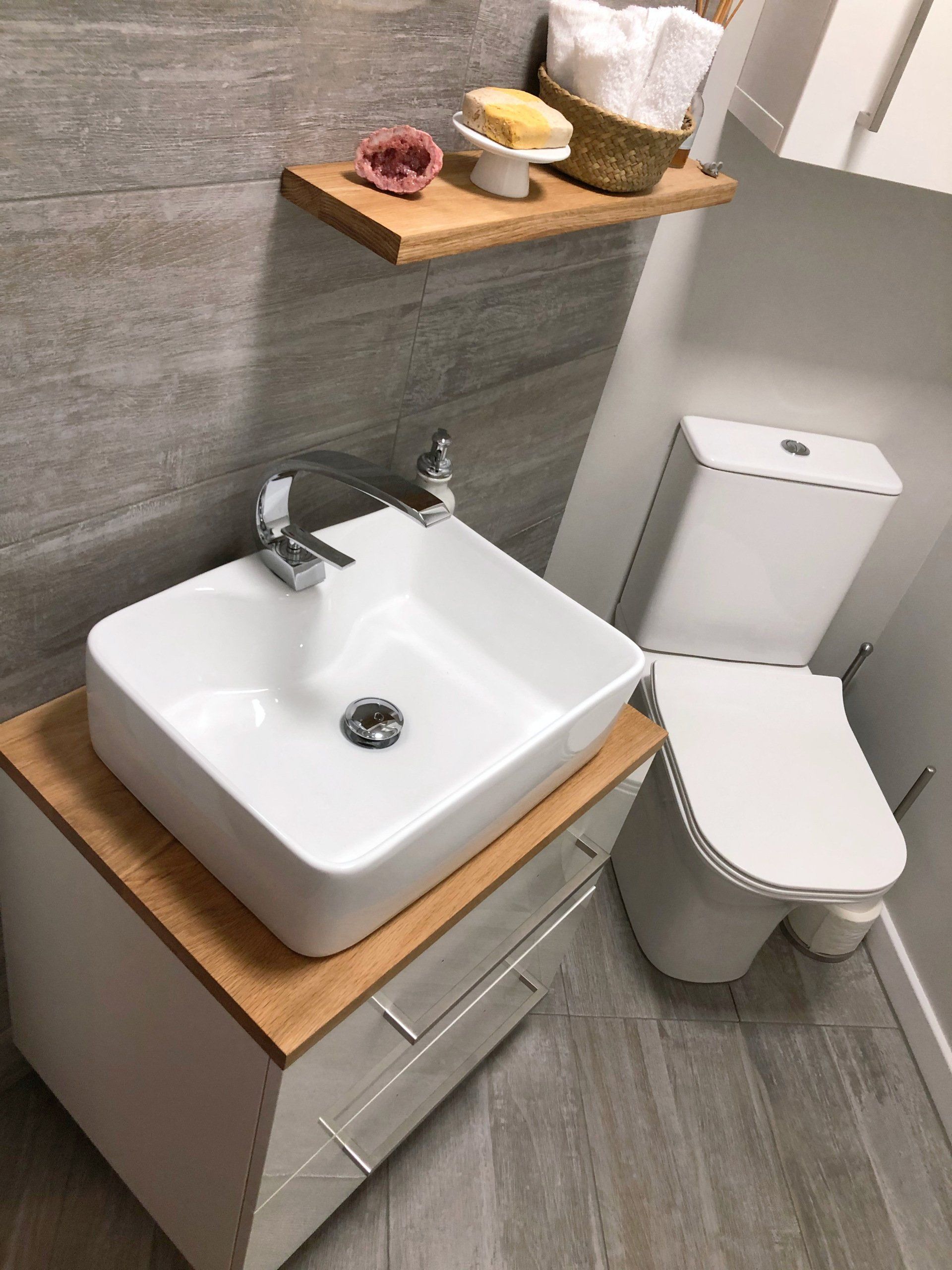A bathroom with a sink and toilet with a wooden top