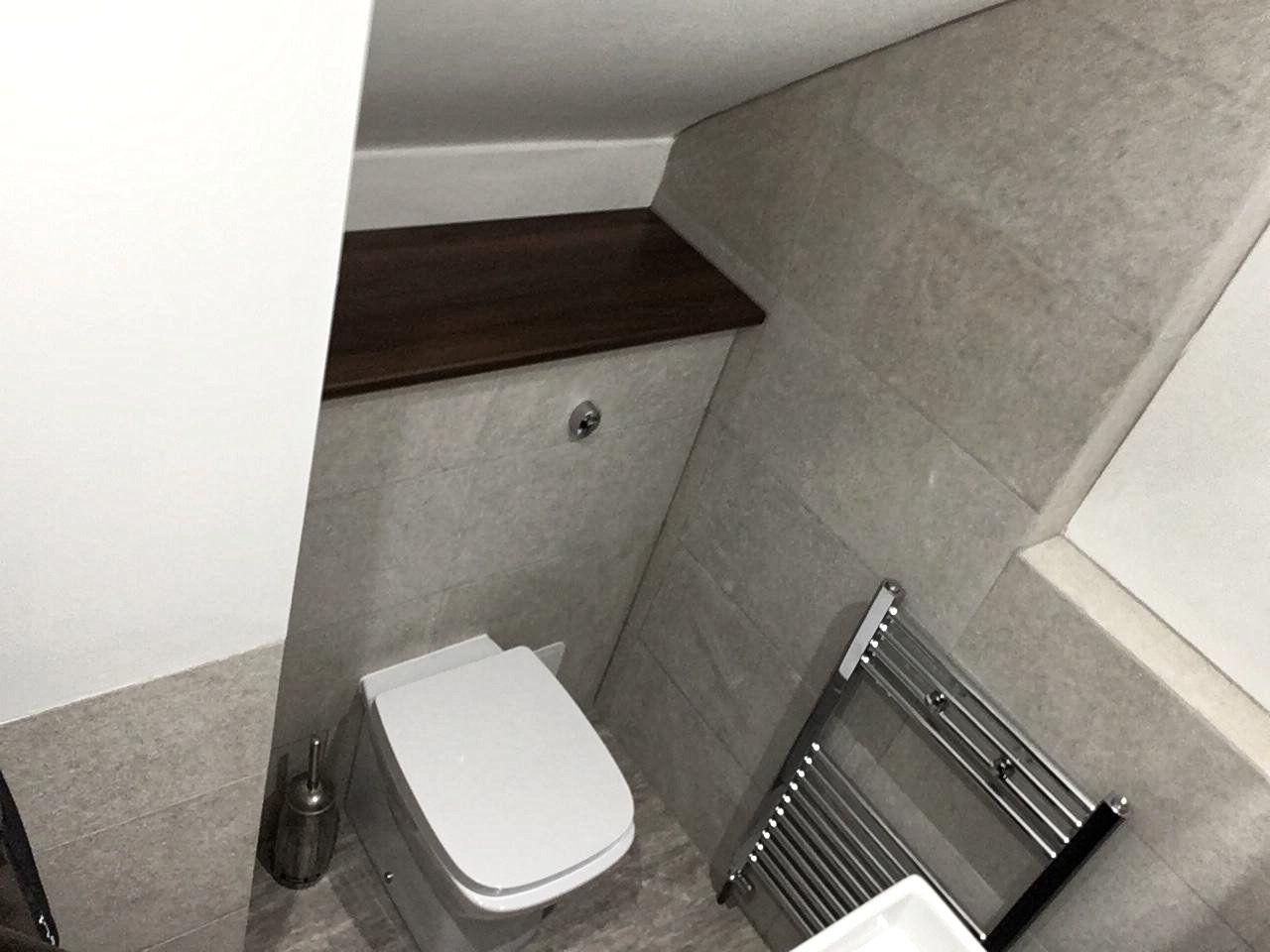 A bathroom with a toilet and a towel rack.
