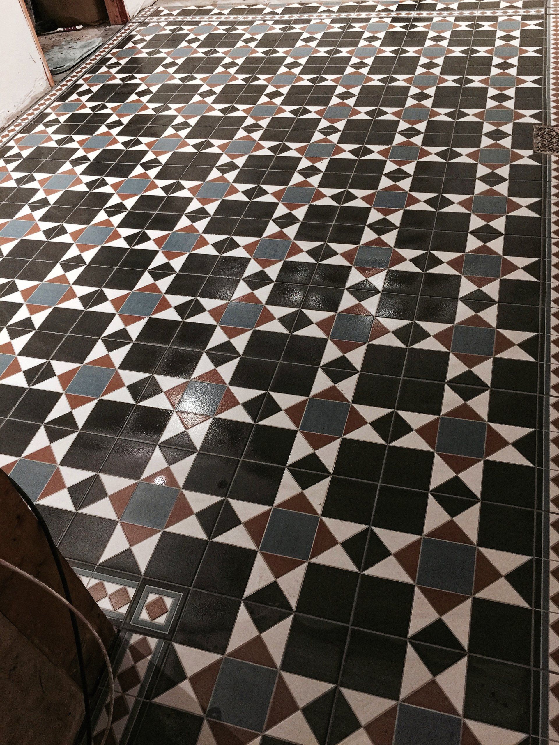A black and white traditional tile floor with a geometric pattern.