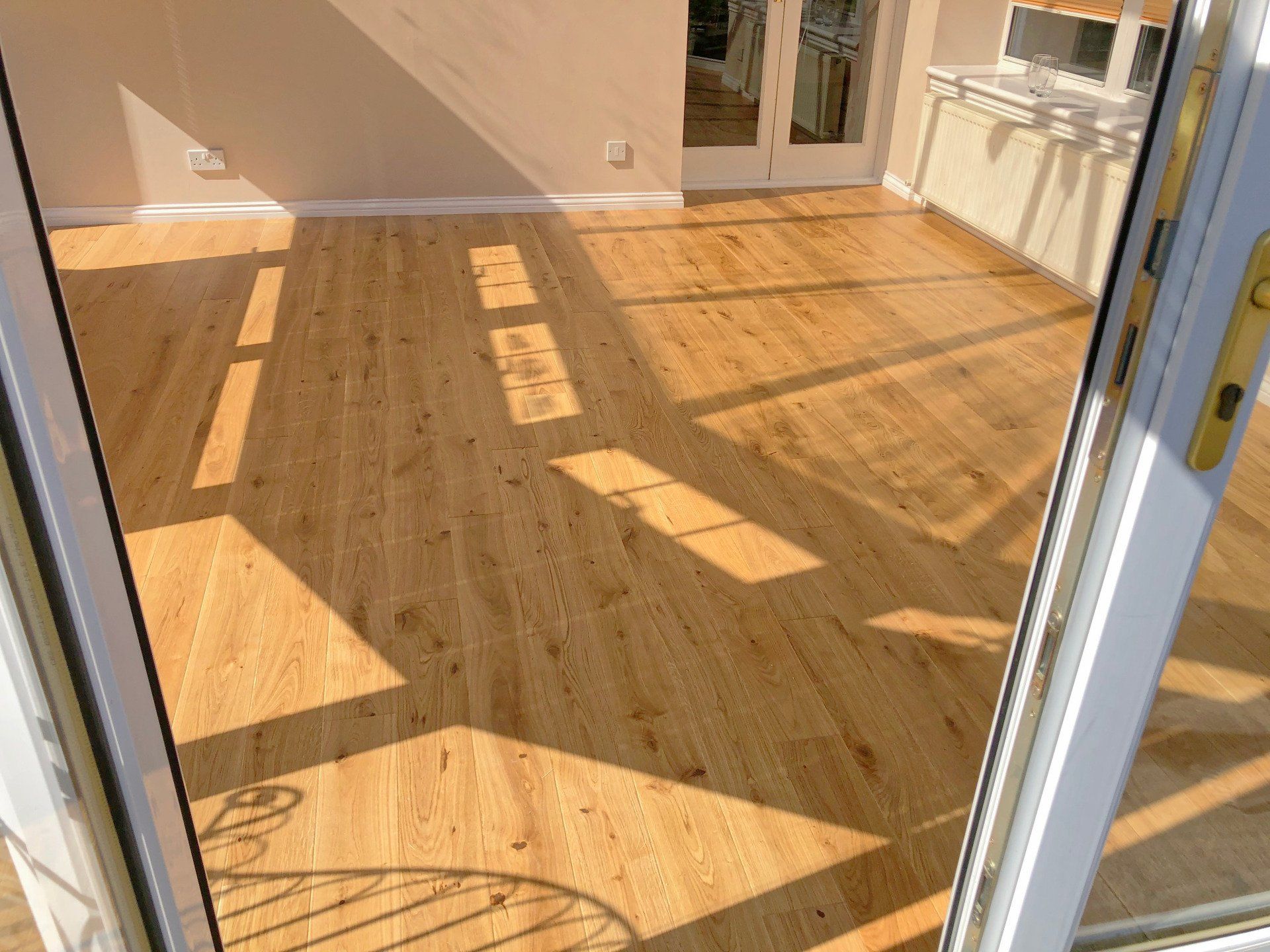 A conservatory with a wooden floor and a sliding glass door