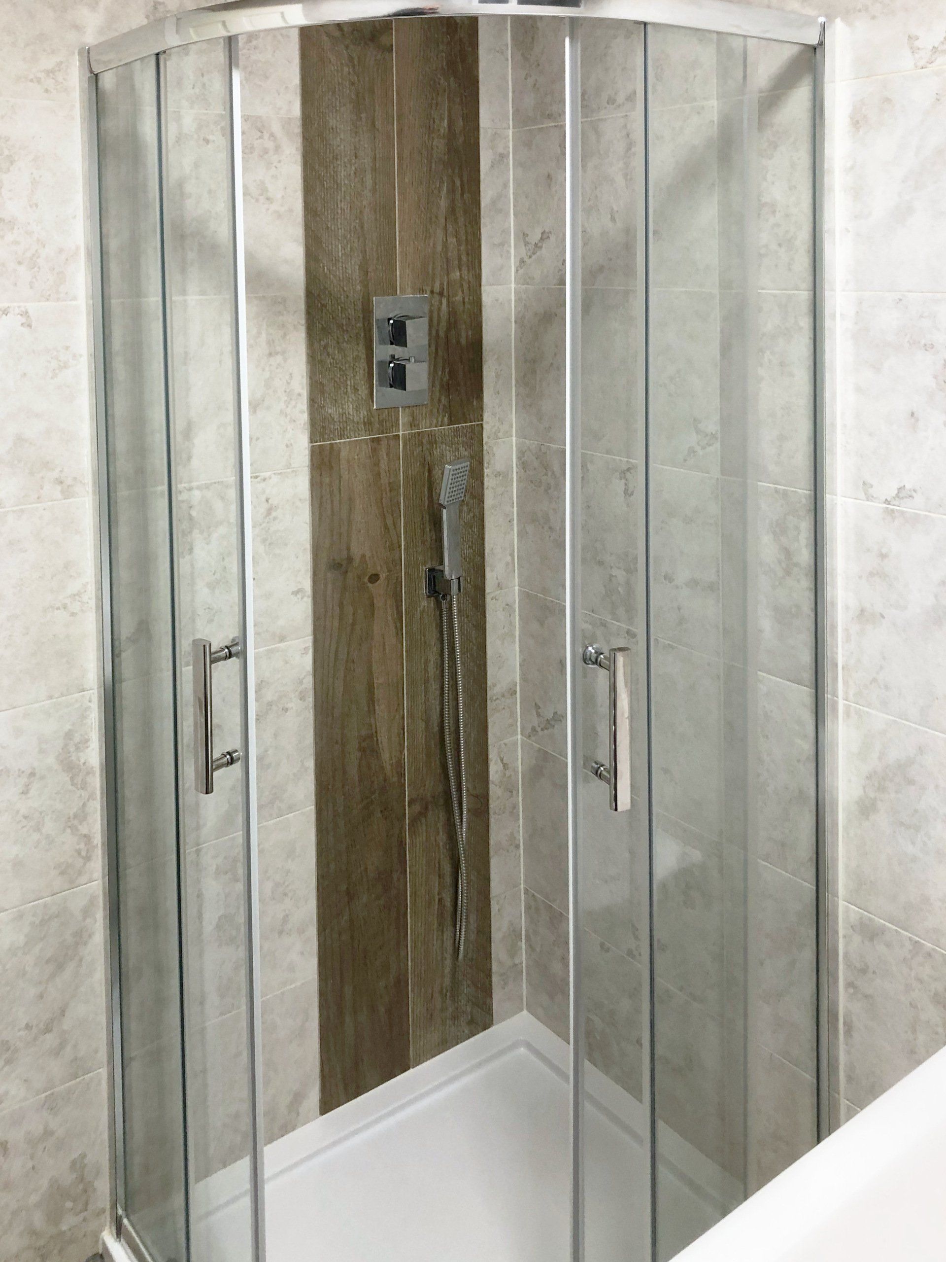 A bathroom with a shower stall and a bathtub.