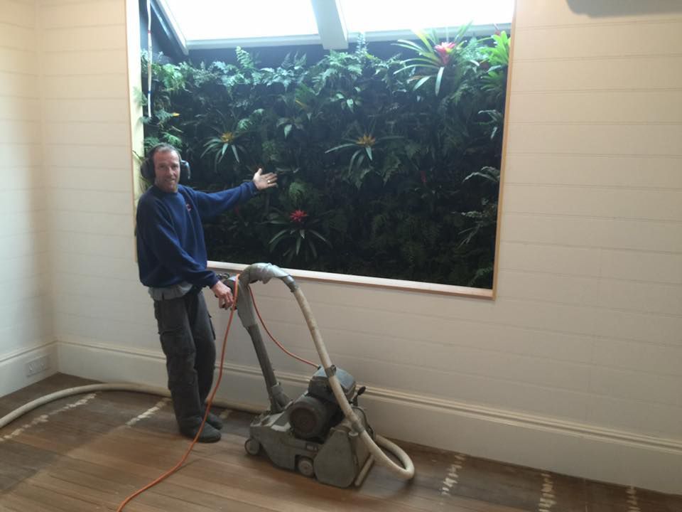A Man Standing Next To A Machine In A Room — Byron Floor Sanding In Byron Bay, NSW