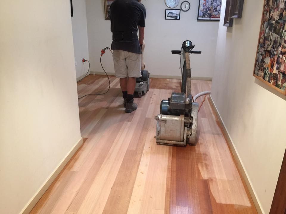 Man Sanding Hardwood Floor in A Hallway with A Floor Sander — Byron Floor Sanding In Goonellabah, NSW