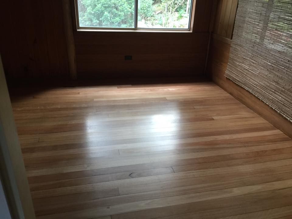 Empty Room with Polished Light Wood Floor, Window, and Wood Paneling on The Walls — Byron Floor Sanding In Goonellabah, NSW