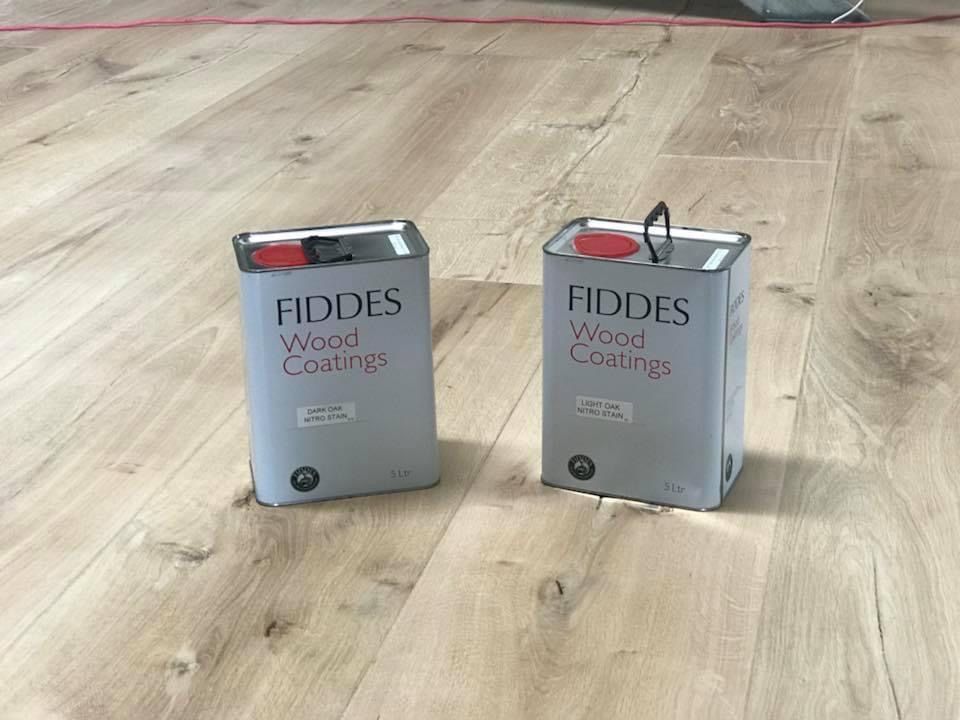 Two Tins of Polish on a Wooden Floor — Byron Floor Sanding In Ballina, NSW