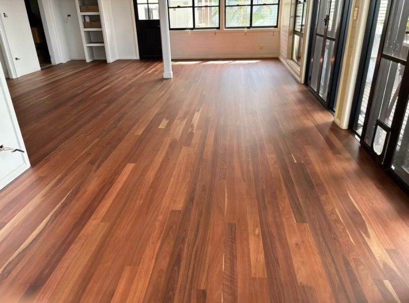 A Room With A Polished Wooden Floor and Windows and a Pole— Byron Floor Sanding In Byron Bay, NSW