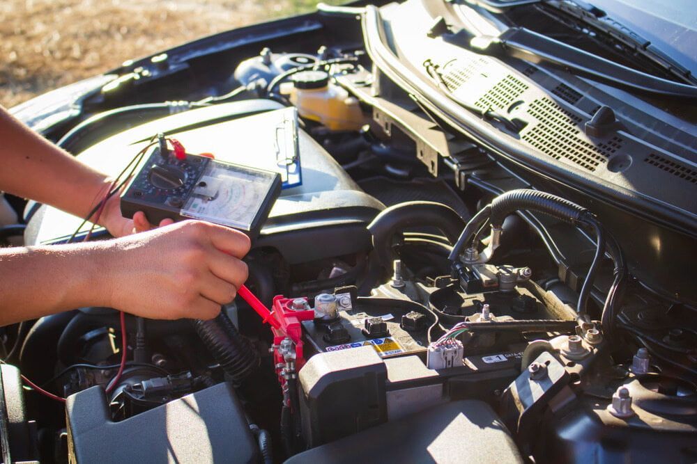 A Person is Working on a Car Battery With a Multimeter — Steve's Service Centre in Albury, NSW