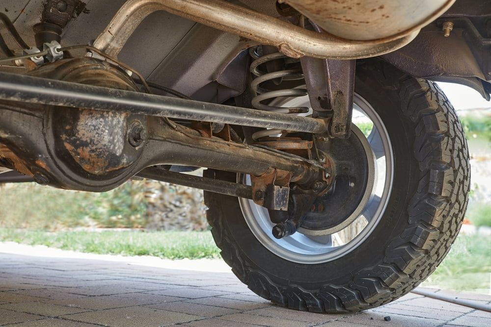 A Close Up of the Underside of a Car With a Tire — Steve's Service Centre in Albury, NSW