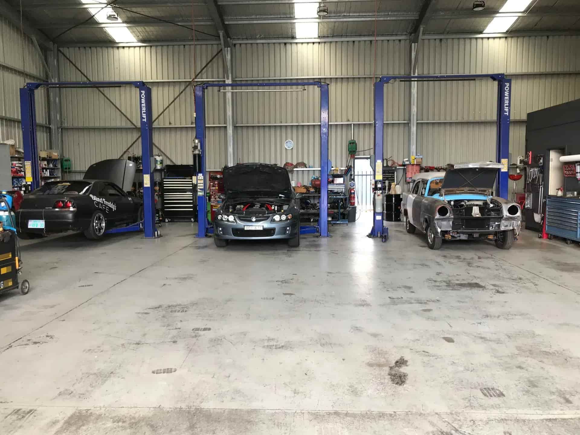 A Row of Cars Are Parked in a Garage With Their Hoods Open — Steve's Service Centre in Albury, NSW 