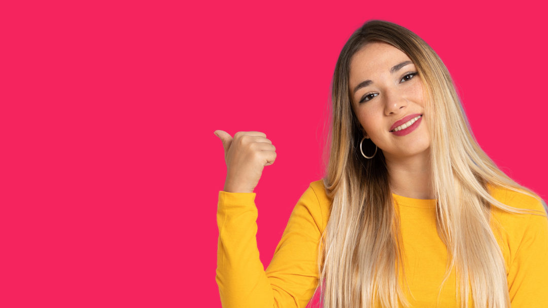 The woman is wearing a yellow sweater and pointing to the side.