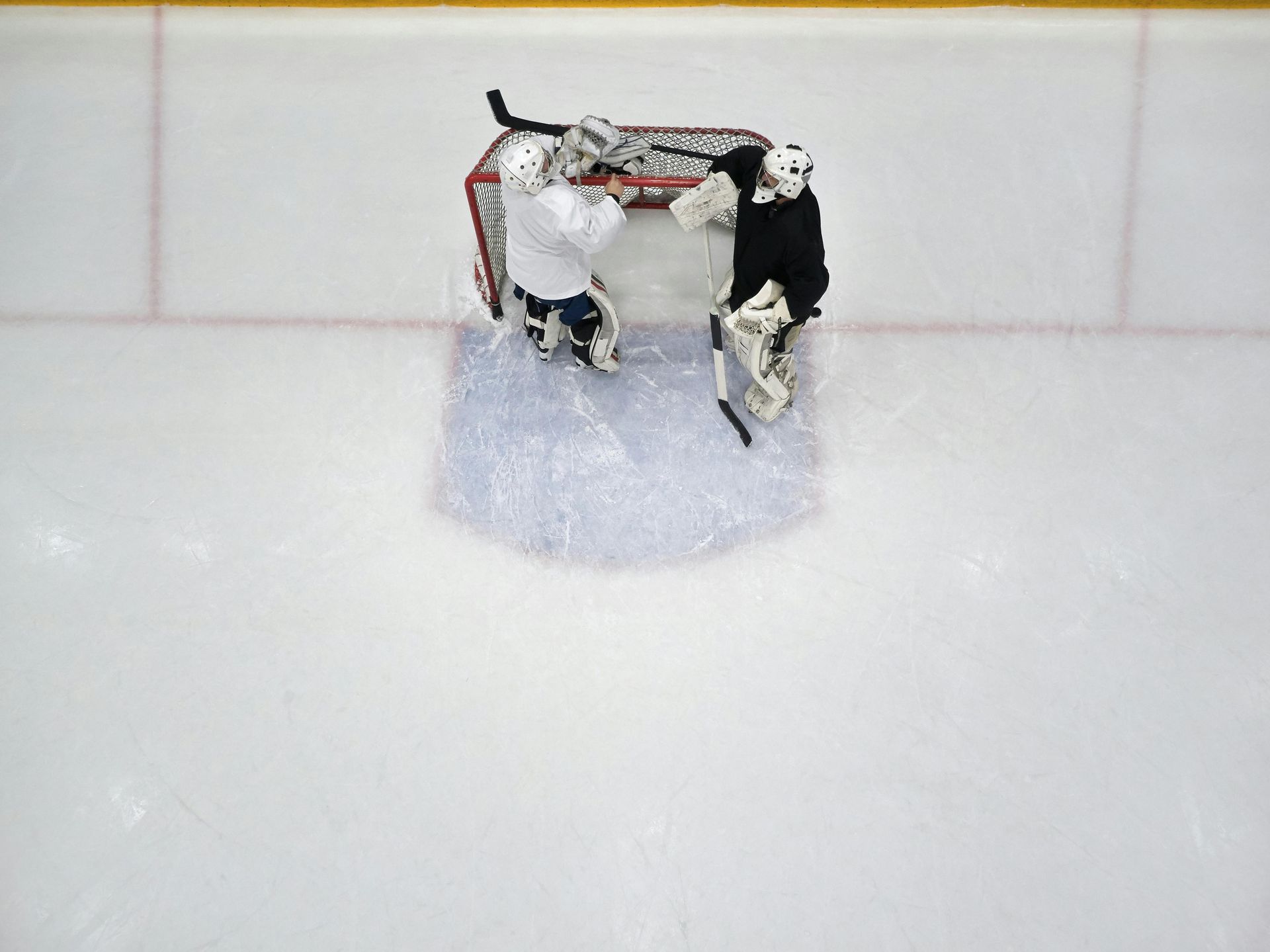 Two hockey players are playing a game on the ice