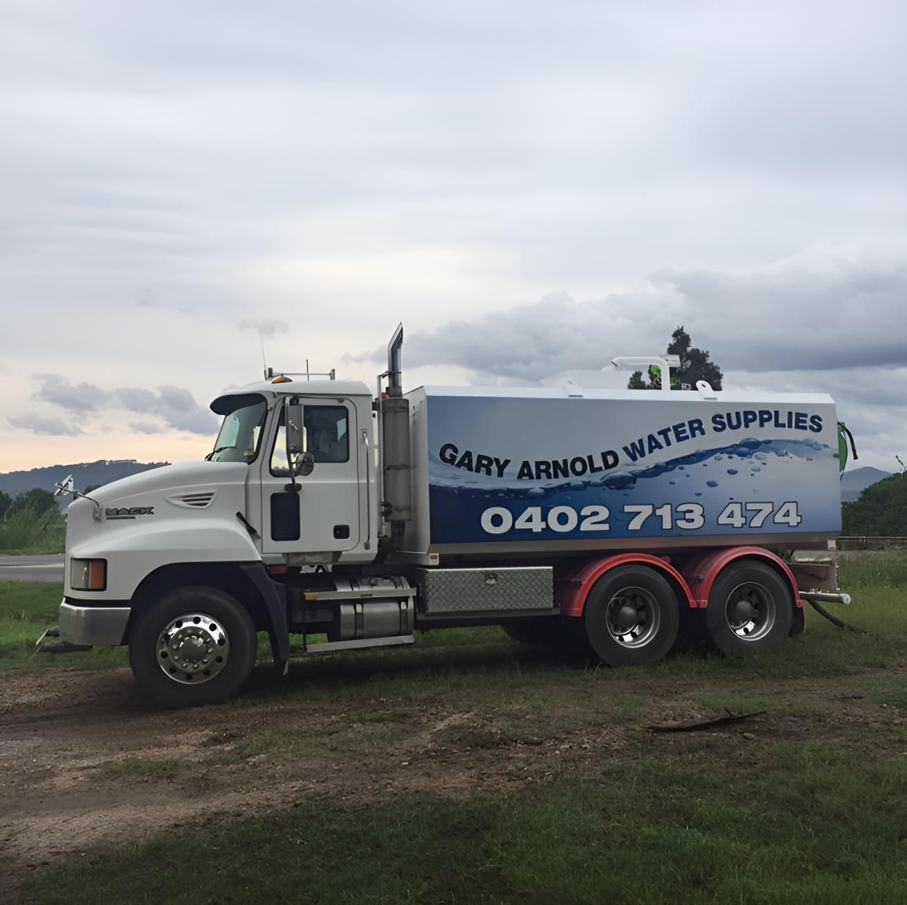 Gary Arnold Water Supplies Truck is Parked in a Grassy Field — Gary Arnold Water Supplies in Byron Bay, NSW