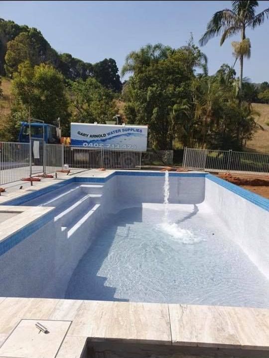 A Large Swimming Pool Is Being Built With A Sign In The Background — Gary Arnold Water Supplies in Uki, NSW