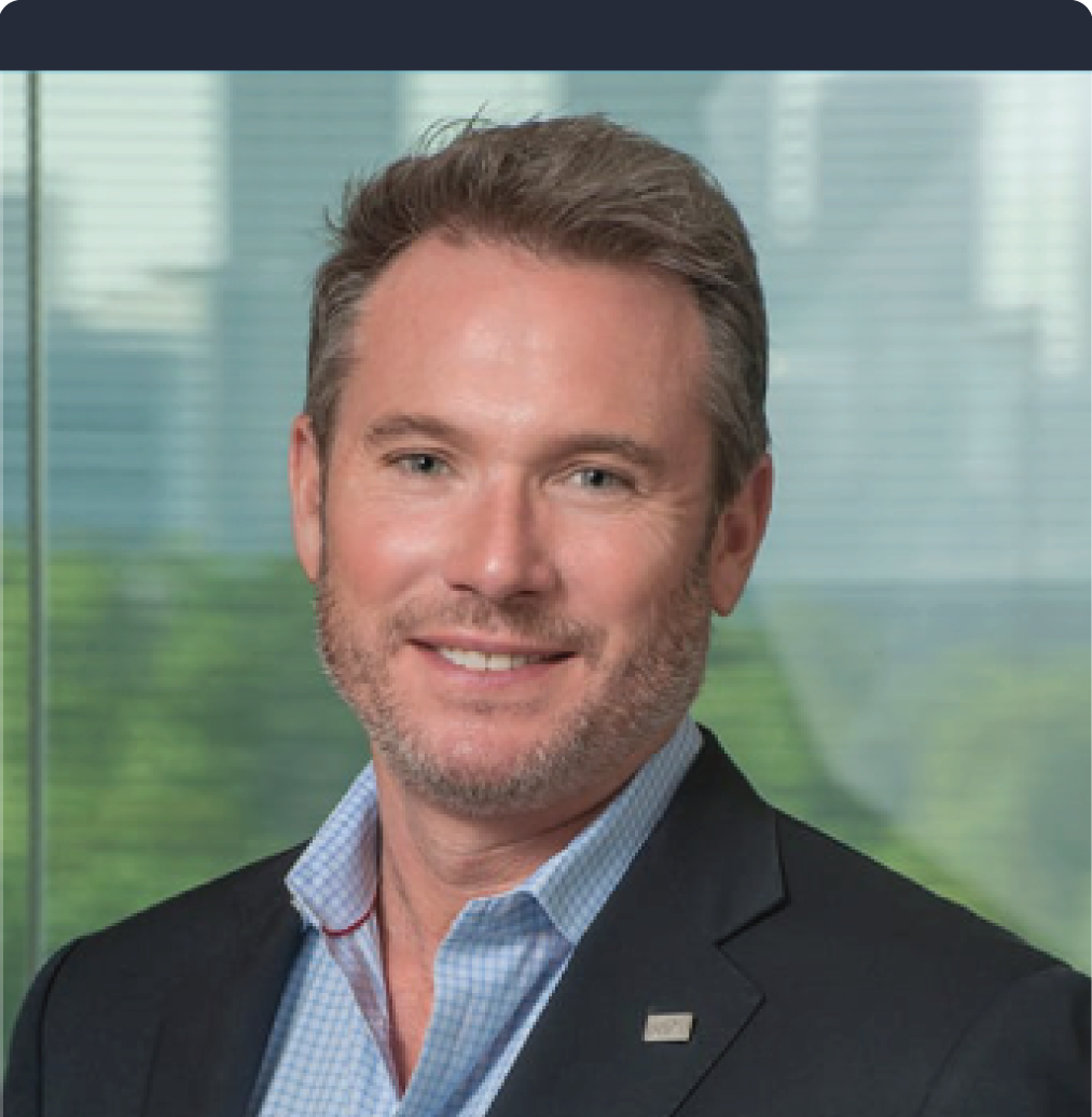 A man in a suit and blue shirt is smiling for the camera.